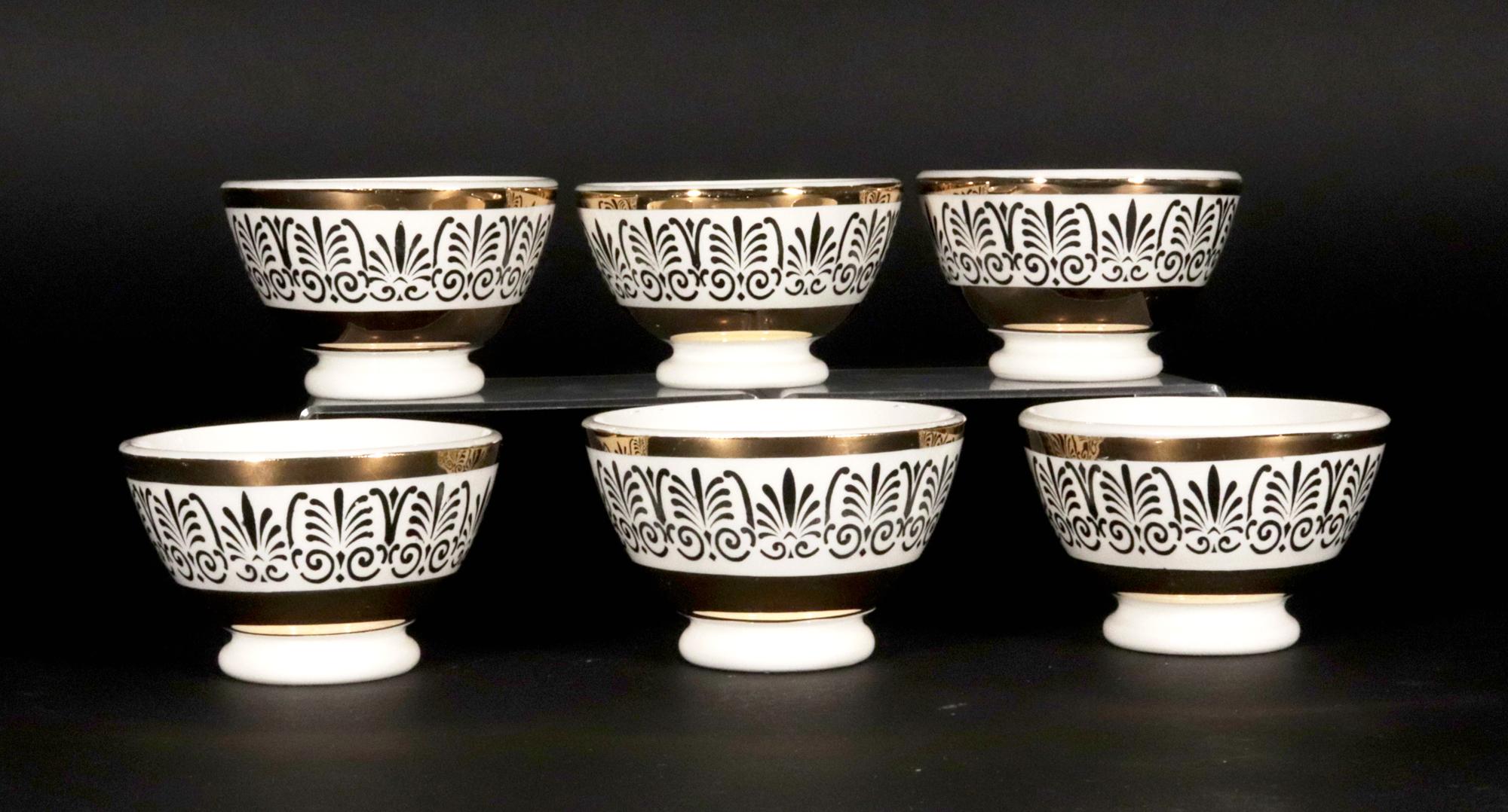 Piero Fornasetti Ensemble complet de six bols à apéritif en céramique,
Circa 1960

Les bols à apéritif en céramique de Piero Fornasetti présentent tous le même décor avec une large bande d'Anthemion entre deux bandes d'or.

Marque : La marque