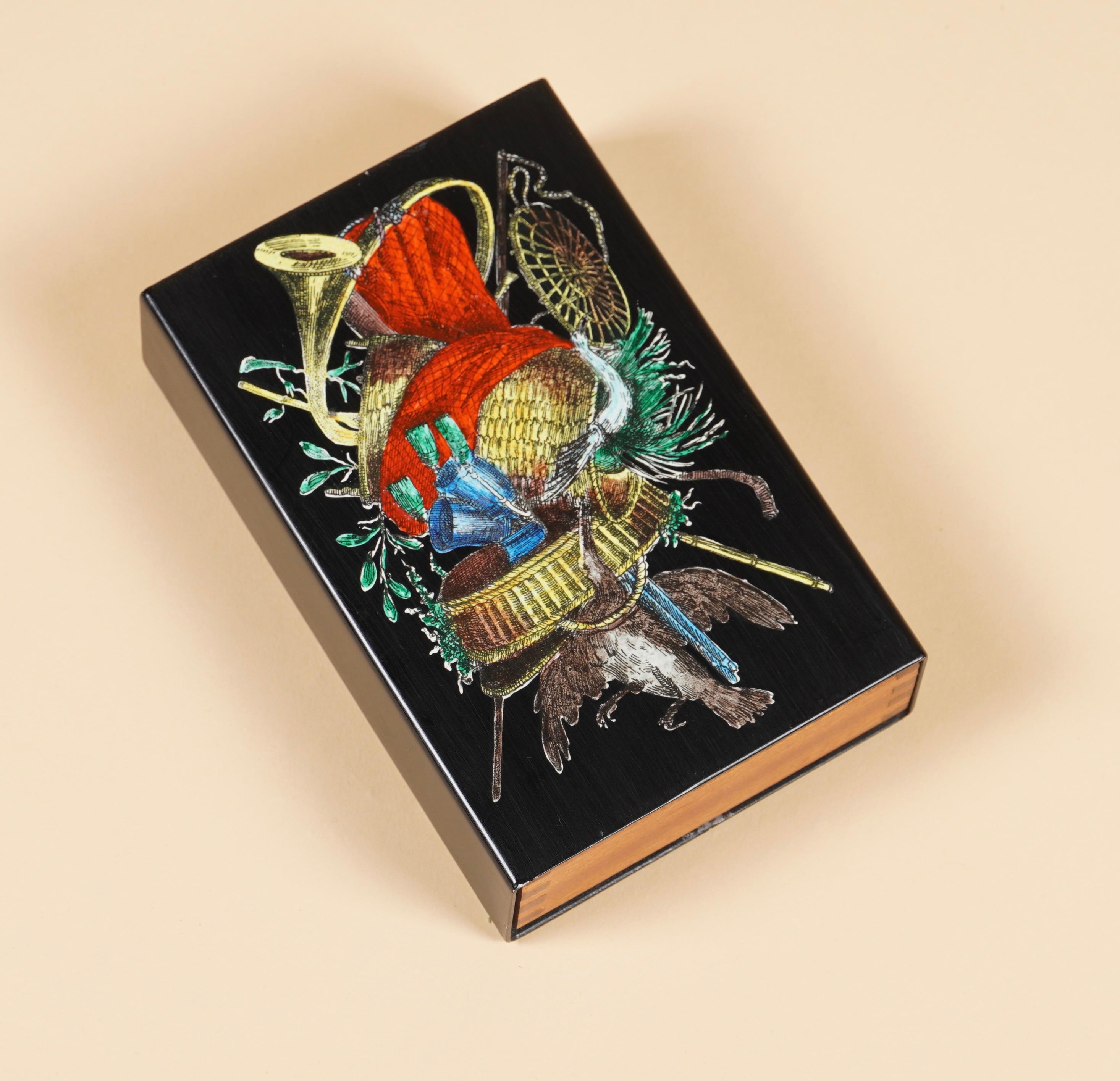 Lacquered metal box with a wooden sliding drawer held into place with spring tension. The wooden box is finely crafted with finger joinery and the bottom still retains the green Fornasetti bottom pad.