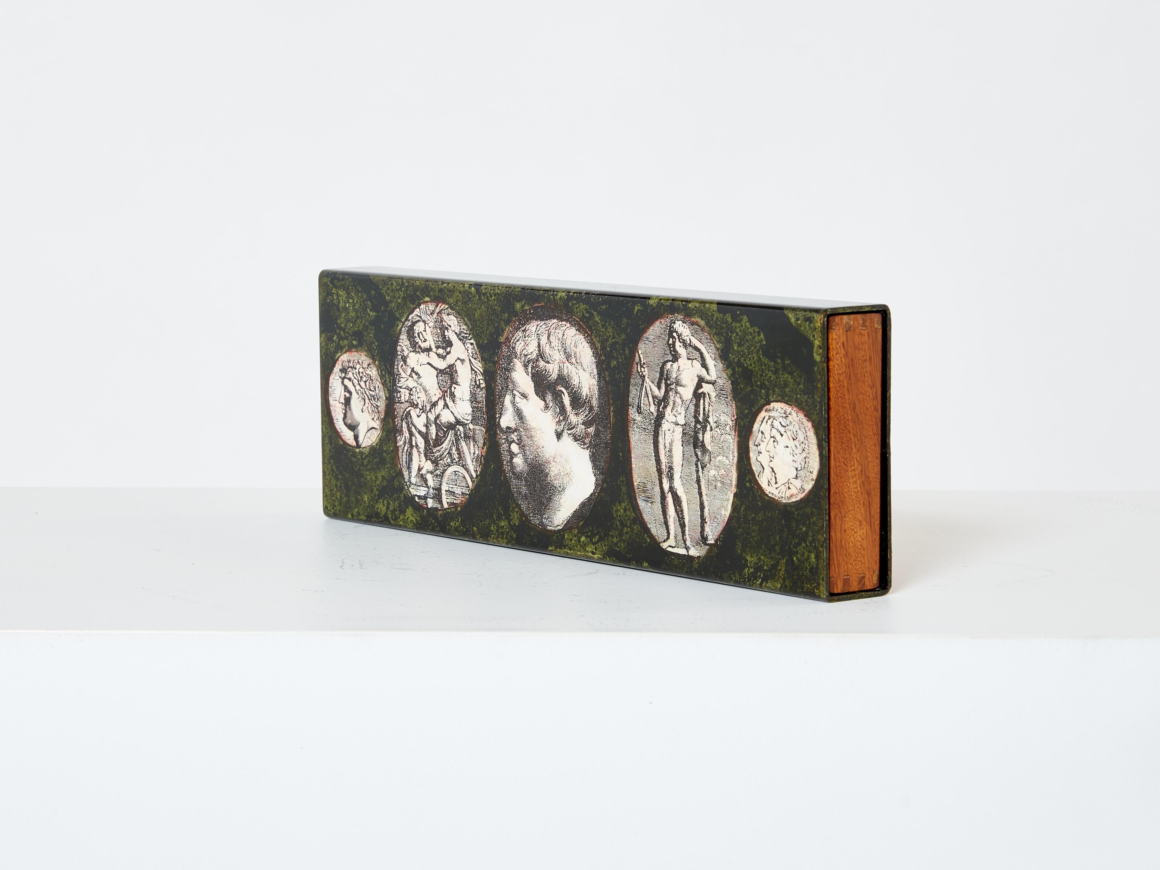 Beautiful Piero Fornasetti decorative box made in Italy in the 1950s. This box is made of enameled metal with a slide out wooden drawer from mahogany wood. This box, originally a cigar box, was designed by Piero Fornasetti in the 1950s and is listed