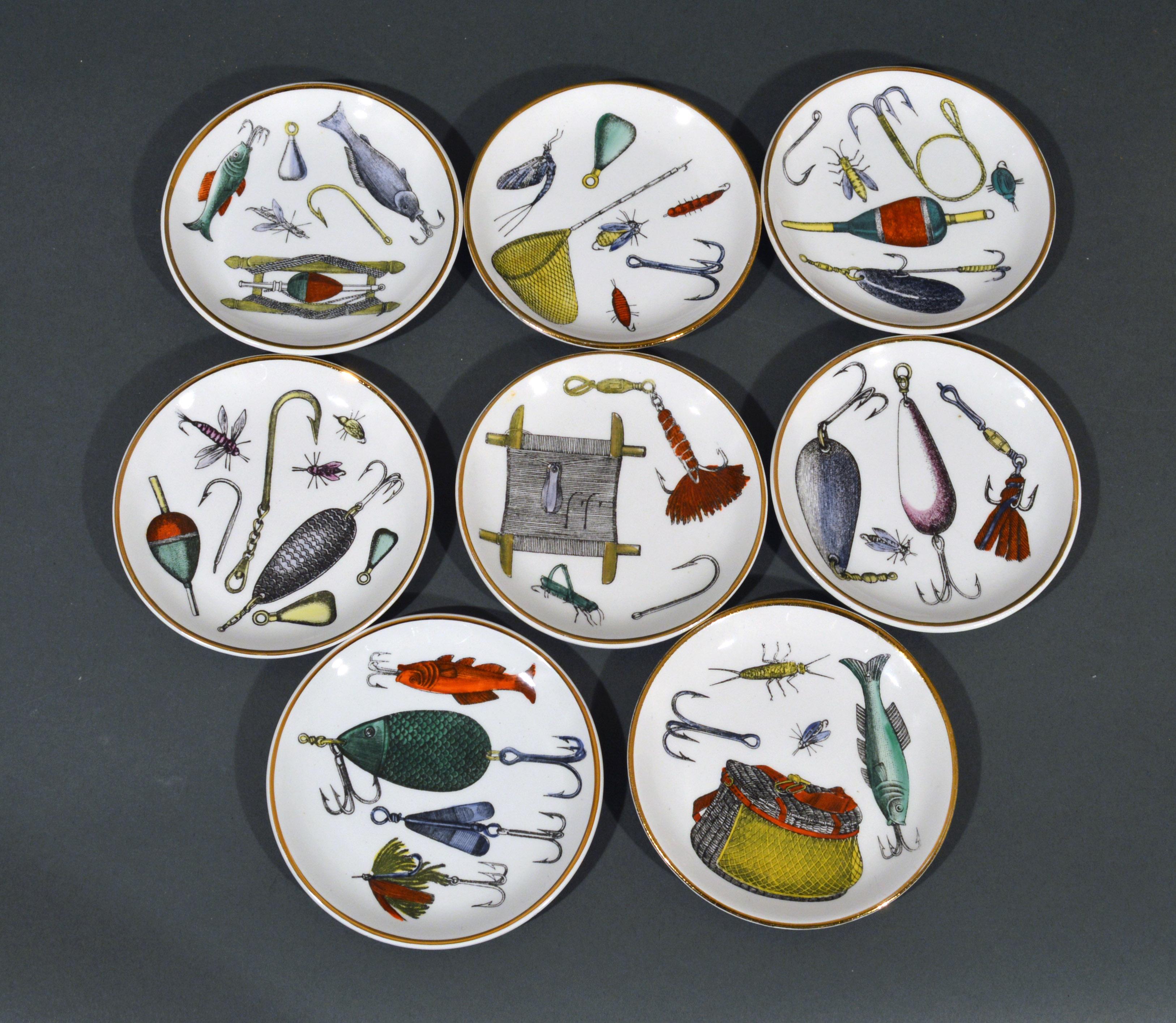 Piero Fornasetti fishing lures coaster set with original box,
La Pesca Pattern,
1960s.

A full set of eight coasters or small dishes each decorated with the rare pattern of fishing lures and fishing tools such as nets and bags. All within a gold