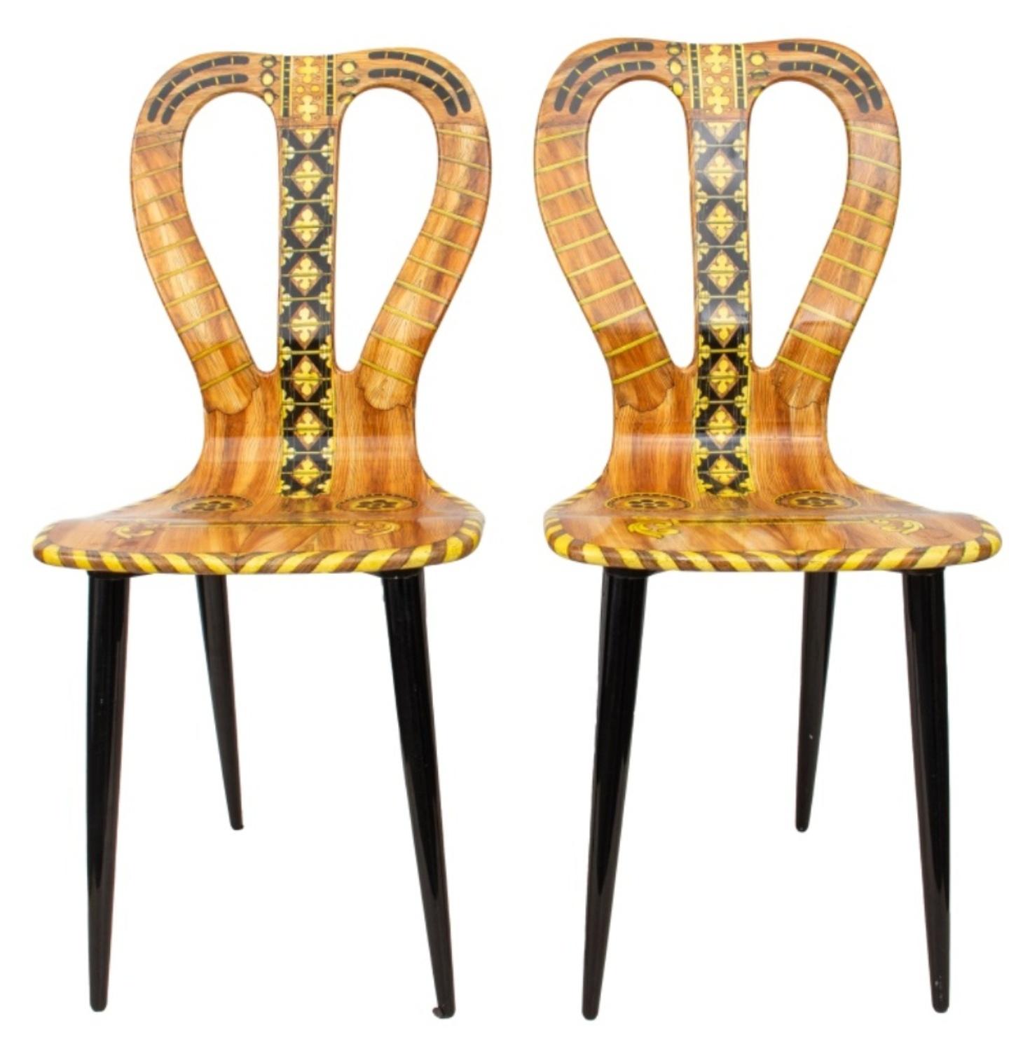 Piero Fornasetti (Italian, 1913-1988) pair of Musicale guitar chairs, lithographed and lacquered wood, originally designed 1951, marked on bottom and with signature on lower back.

Dimensions: 37.75