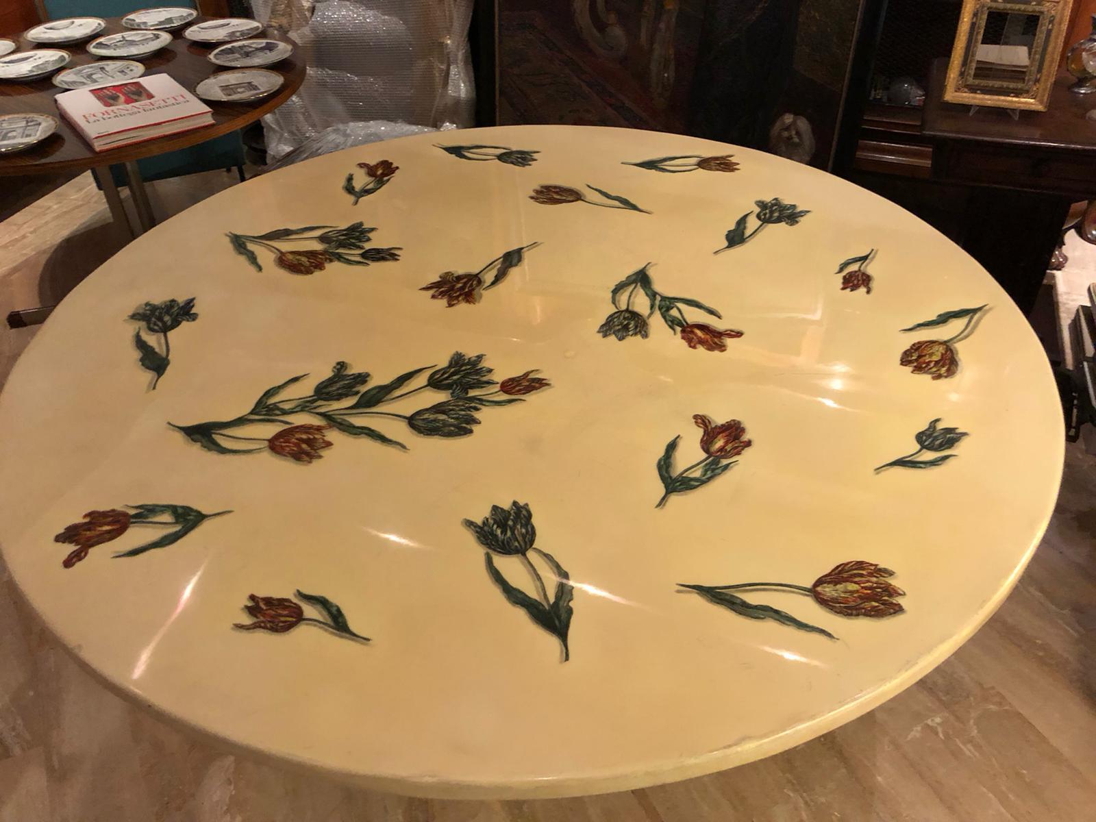 Large round and amazing dining table designed by Piero Fornasetti, with black painted metal base and resin top decorated with tulips, designed by Piero Fornasetti in the 1950s. Unique piece.
Adhesive label under the top.

Please note that the