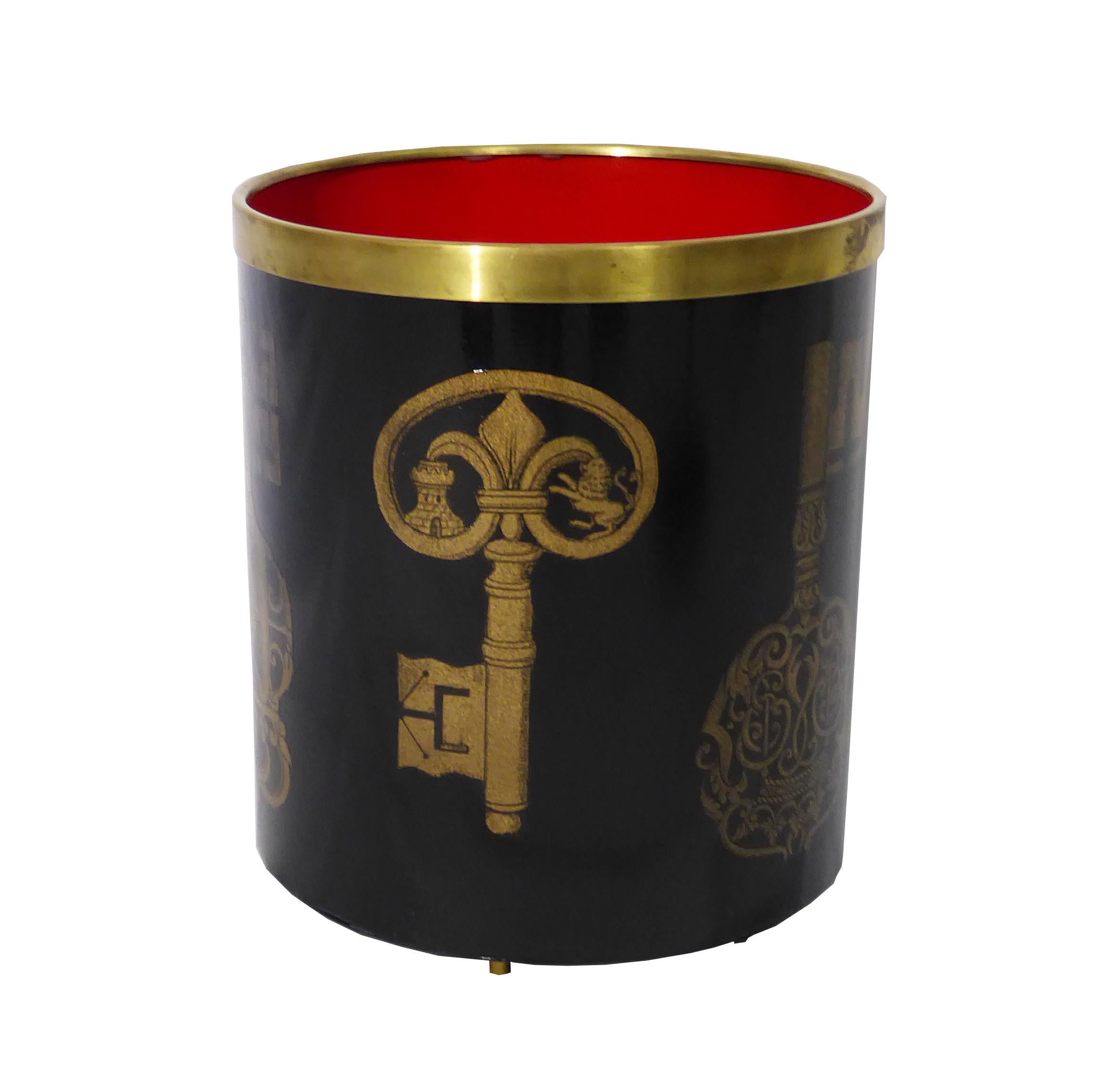 Elegant Fornasetti Italian modernist waste basket. It has an ebonized finish with stencilled key design. Brass trim and feet, lush red color interior. Marked Fornasetti Milano, Italy. Lithographed on metal.