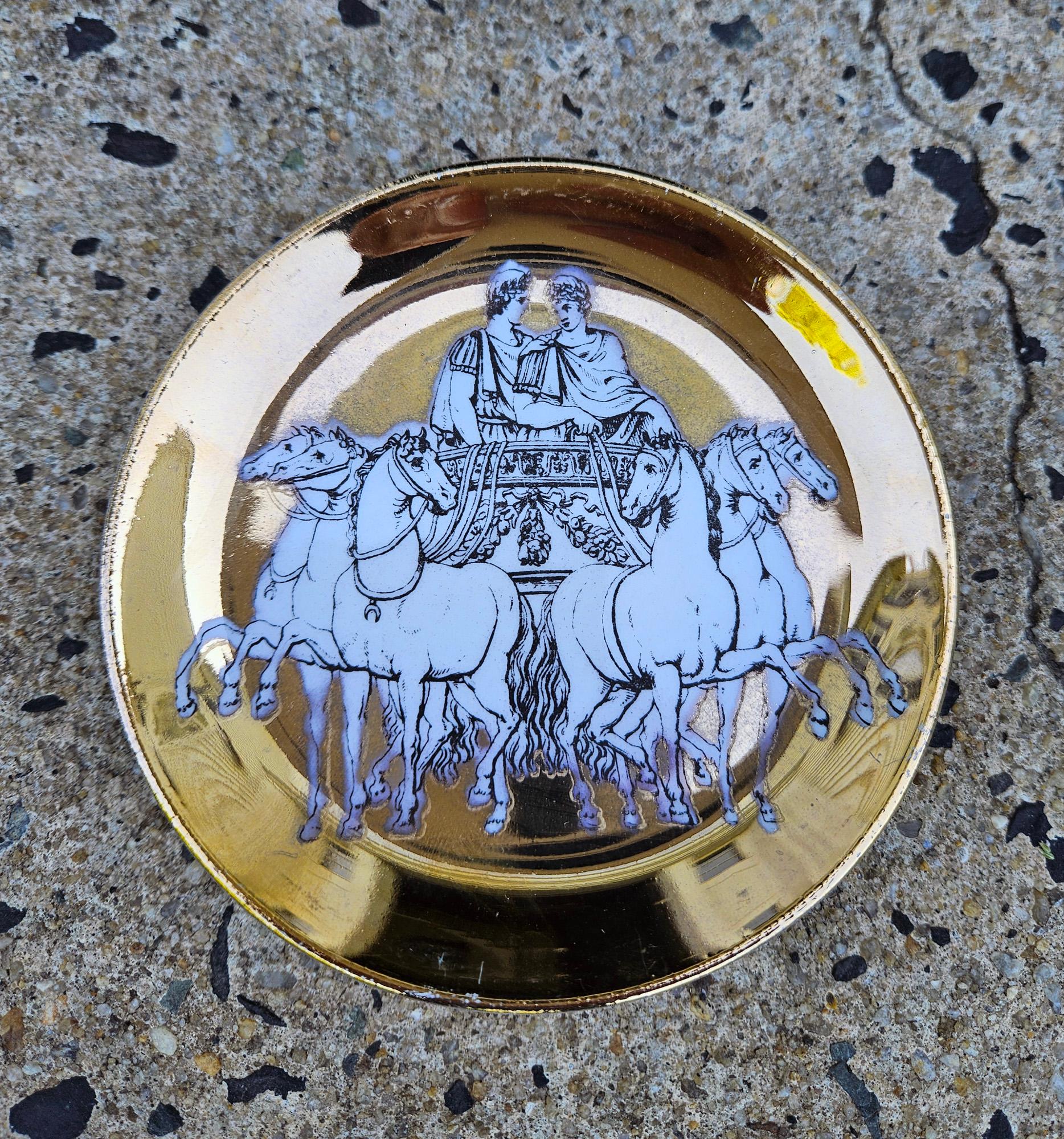 Piero Fornasetti Satz von acht Untersetzern mit römischen Streitwagen auf Goldgrund,
Exklusiv für Saks Fifth Avenue hergestellt,
Mit orange-weiß bedruckter Schachtel,
1950 - Anfang der 60er Jahre.

Jeder Untersetzer ist in ähnlicher Weise mit einem