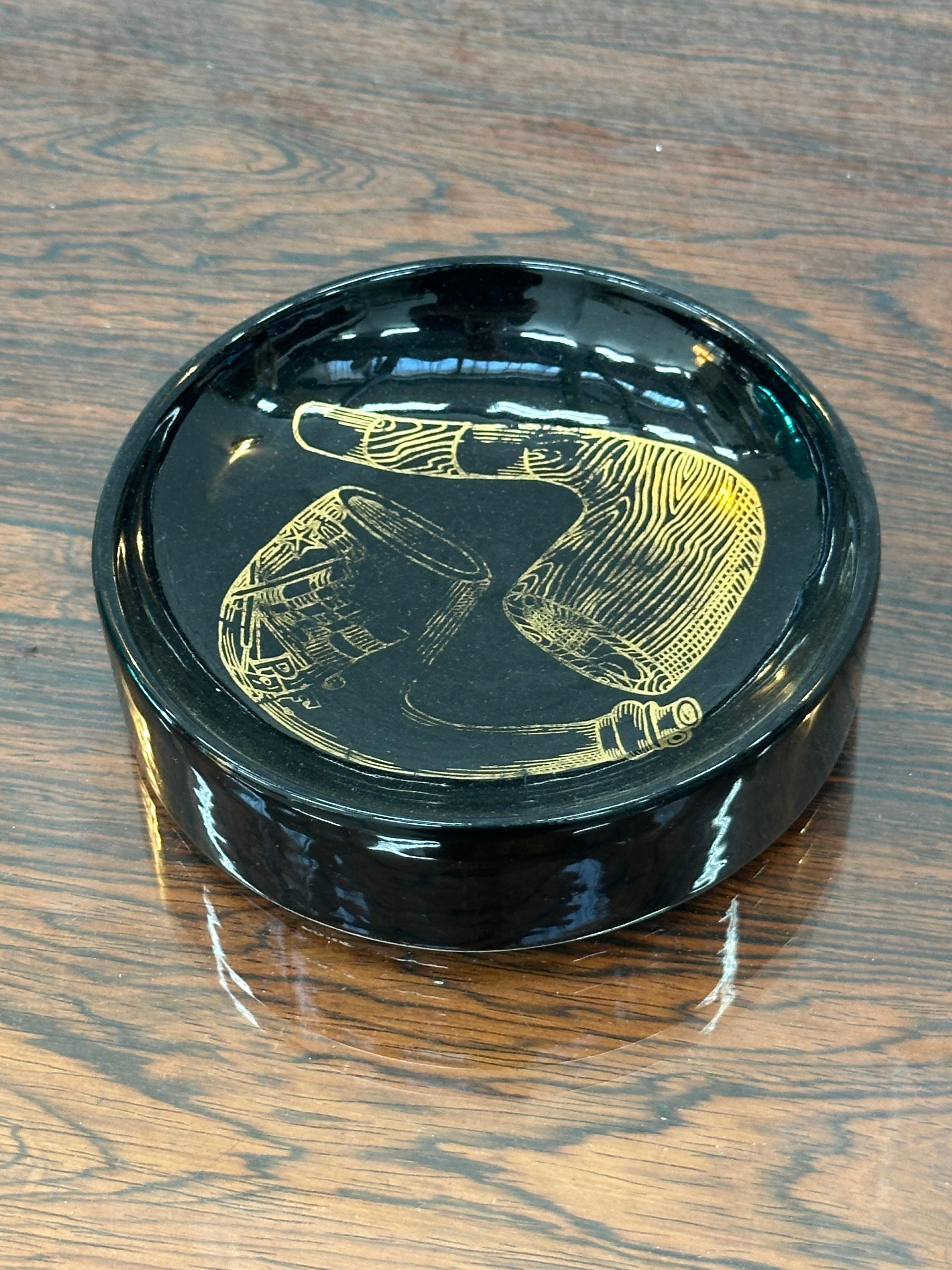 Cenicero de porcelana italiano - Piero Fornasetti, Años 60

Magnífico cenicero de porcelana esmaltada en negro, adornado con un motivo de pipa dorada, firmado por el gran diseñador italiano Piero Fornasetti, de la década de 1960.

Pieza icónica que
