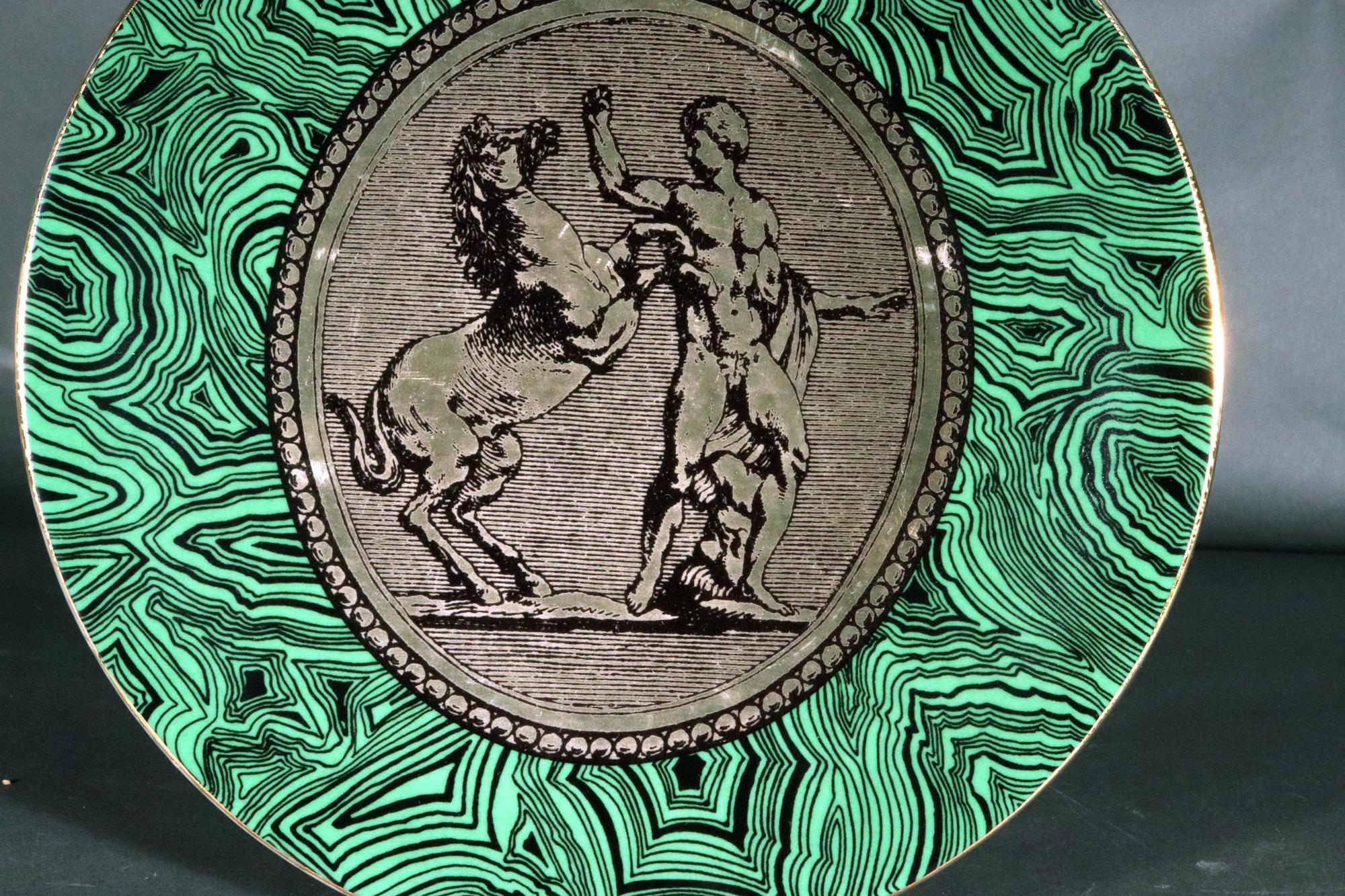 Piatto Cammei in porcellana Greene & Greene Greene Cammei di Piero Fornasetti,
Cammei o Cameo,
Circa anni '50-'60

Il piatto in porcellana di Piero Fornasetti, chiamato al rovescio Cammei, che significa cammeo, ha un fondo di malachite verde con un