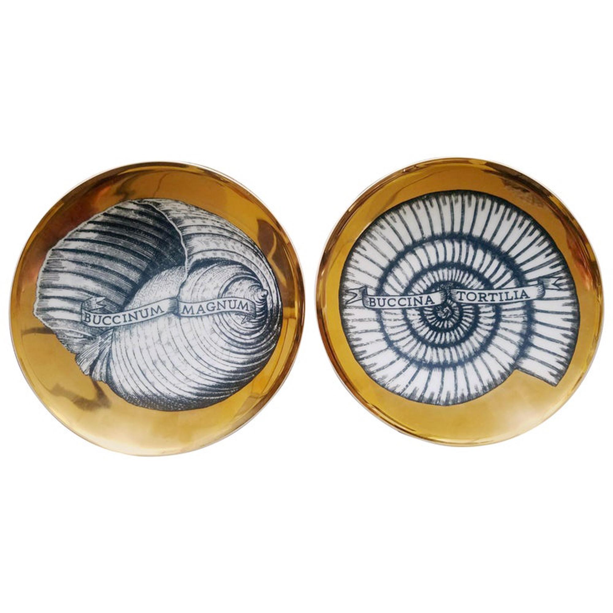 Pareja de platos de concha marina de porcelana dorada Piero Fornasetti,
Patrón Conchyliorum,
Juego de seis platos,
circa 1950s.

Este par de rarísimos platos con fondo dorado están bellamente decorados cada uno con una gran concha marina