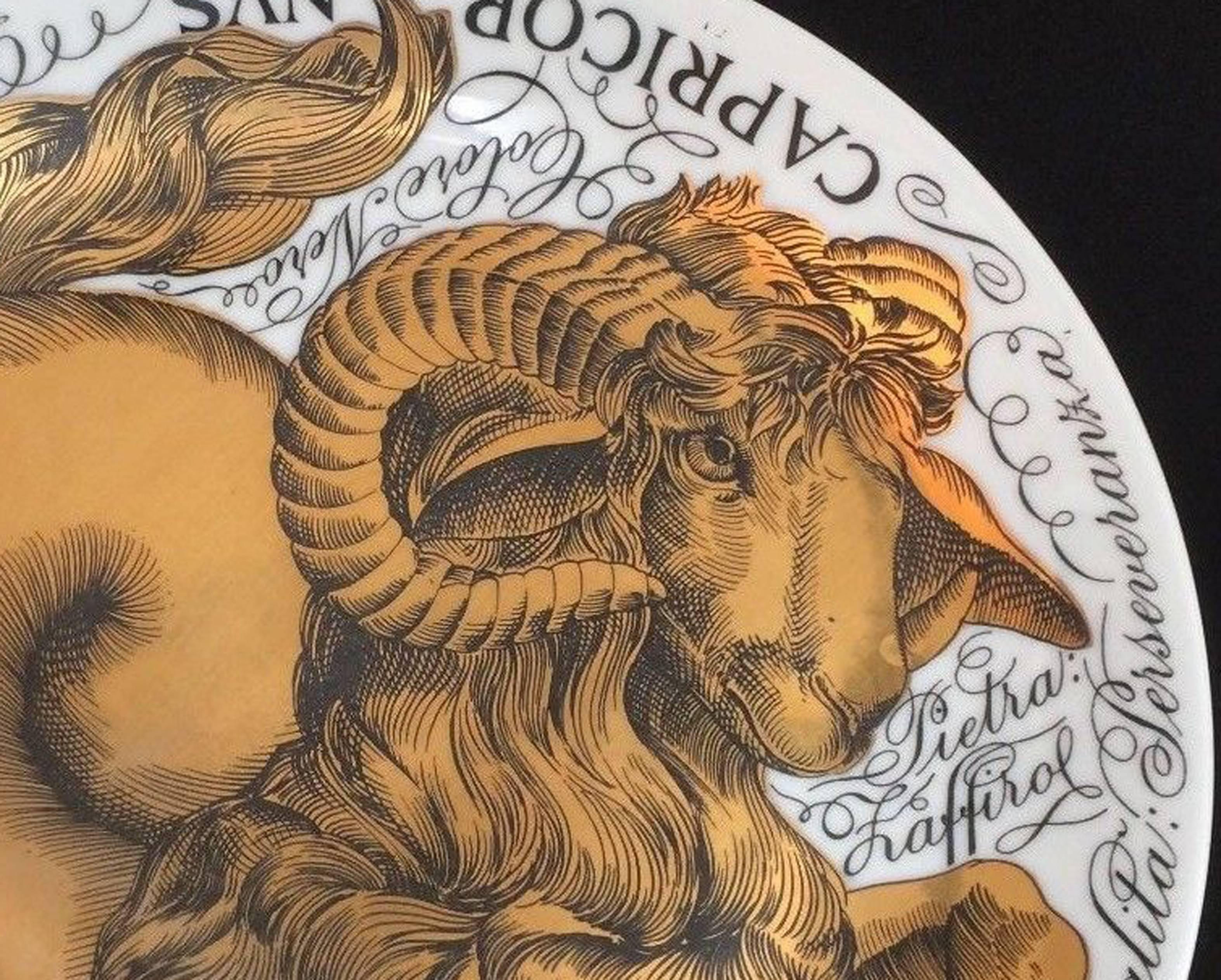 Vintage Piero Fornasetti Porcelain Zodiac plate,
Astrali pattern,
Capricorn,
Made for Corisia, dated 1964; number 1.

The plate in black and gold depicts the astrological sign CAPRICORN with words intertwined around the form of the ram with