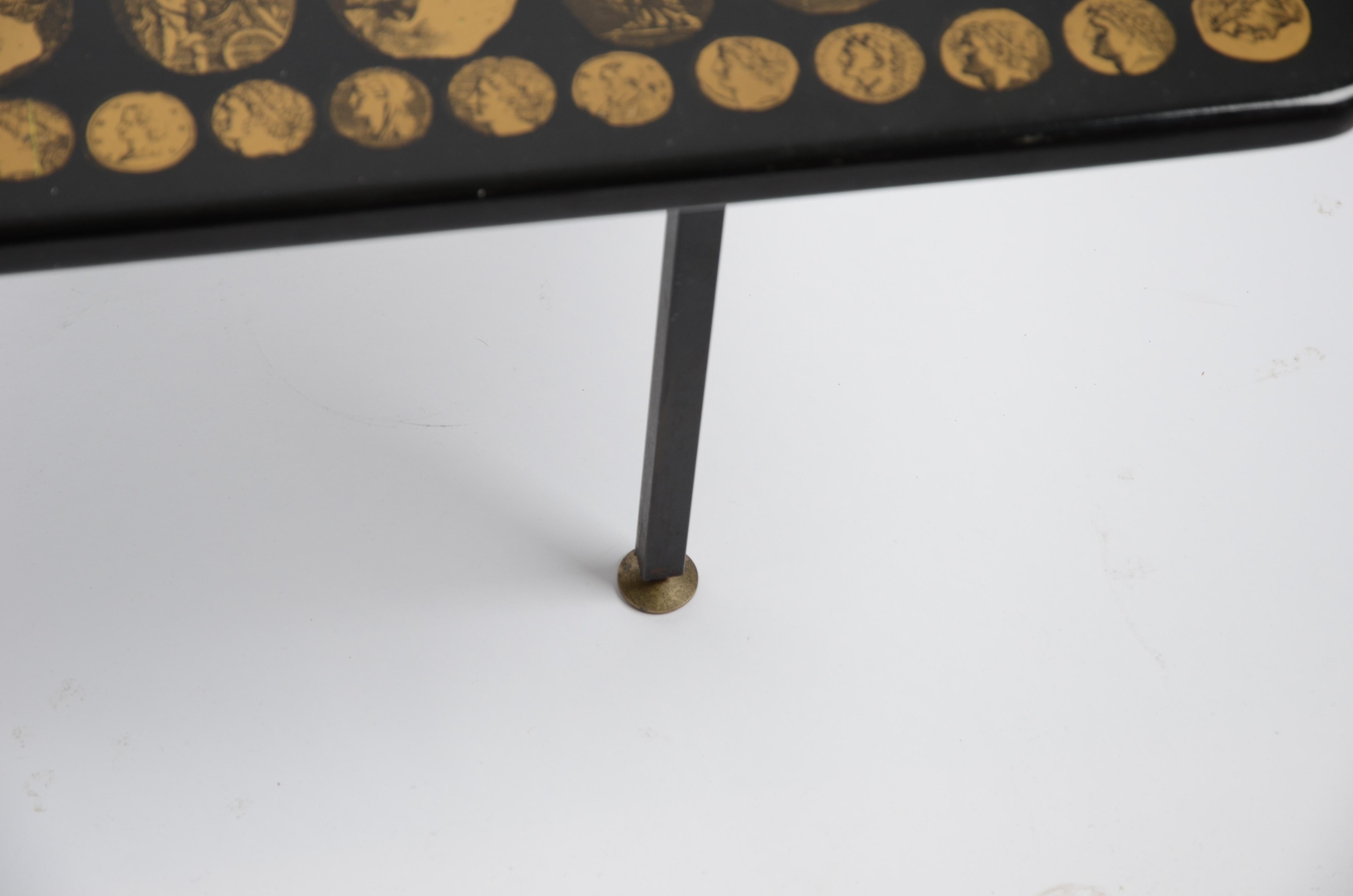 Coffee table by Italian designer Piero Fornasetti, Italy, 1960s. Top with details of Romanesque imagery/ Roman medallions. Lithographic print on lacquered wood and metal base. Manufacturer's label underneath the tabletop.