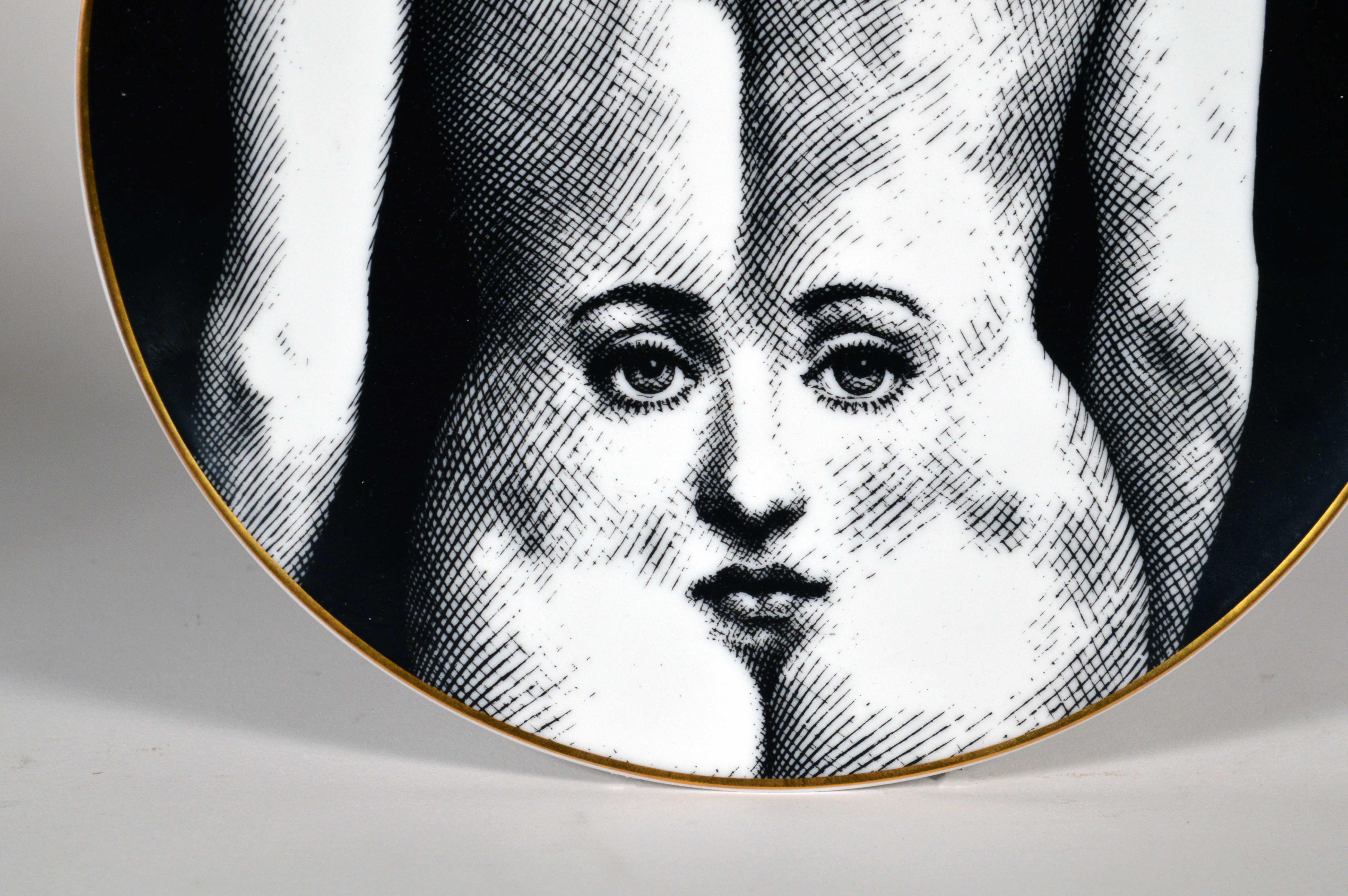 Piero Fornasetti Rosenthal plate, 
Motiv 28,
Depicting the Face of Julia an a Woman's Back,
1980s


The striking Rosenthal Fornasetti gold-rimmed black and white printed plate with the face of Lina Cavalieri depicted on the back of a