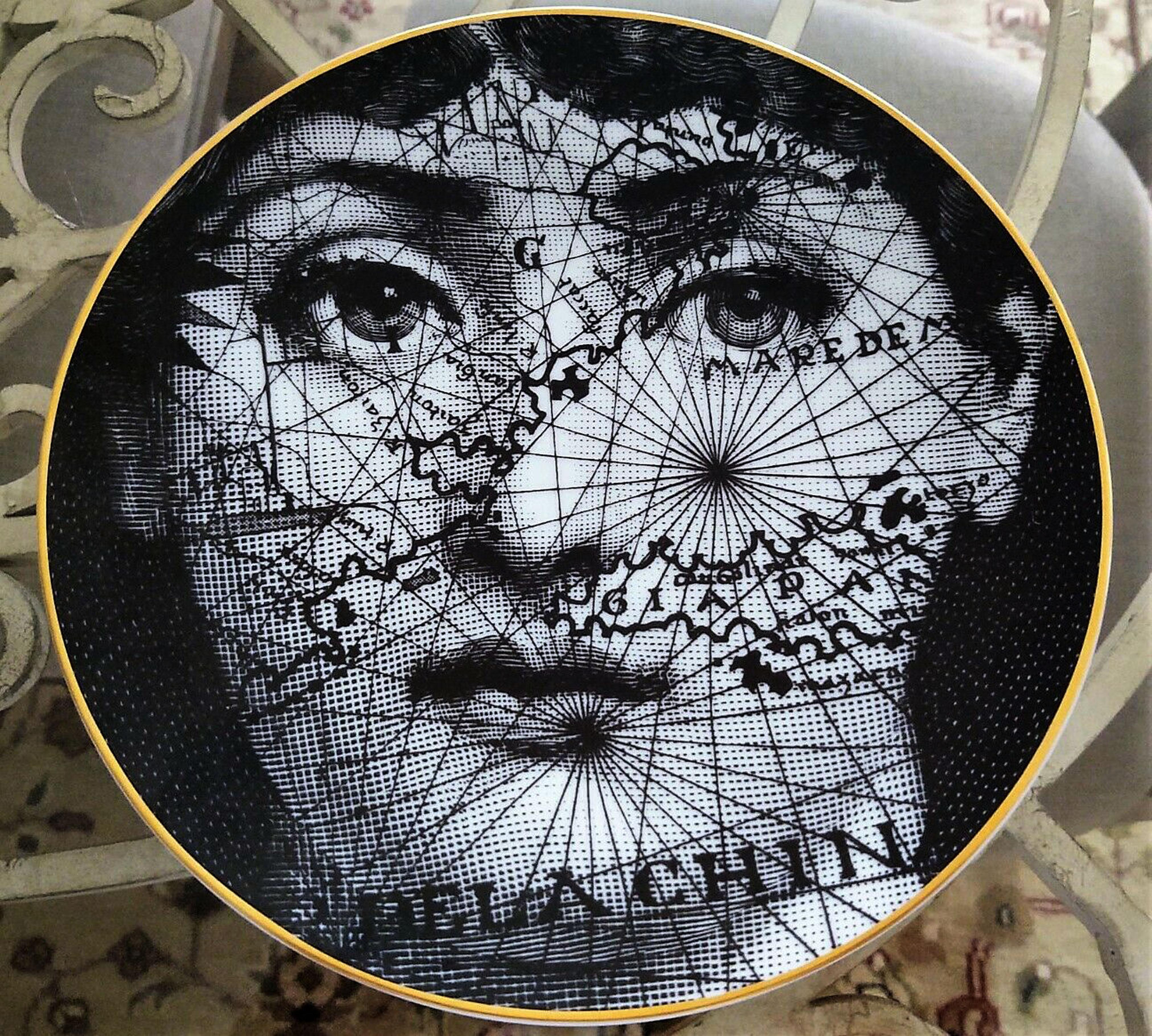 Piero Fornasetti Rosenthal Temi E Variazioni (Themes & Variations) porcelain plate,
 Motiv 31- Map.
1980s.
(Ref: NY9635-cnp)

The Fornasetti porcelain plate from the Themes & Variation series depicts the face of Lina Cavalieri overlaid with an