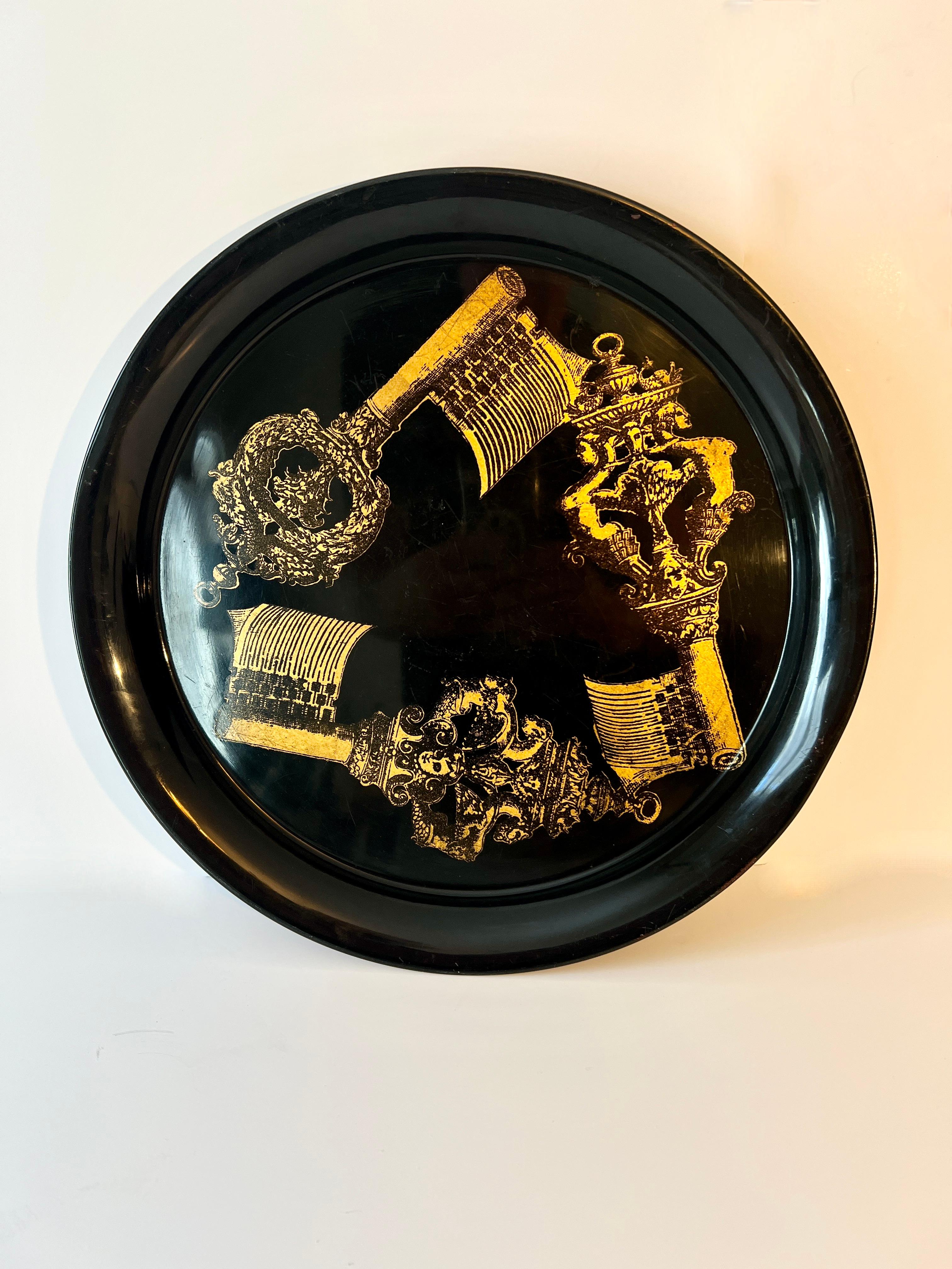 El icónico y coleccionista diseñador Piero Fornasetti es reconocido por su estilo definitivo y sus bandejas son un gran ejemplo de cómo permite que una pieza hable funcionalmente, además de ser una importante pieza decorativa.

Un complemento para