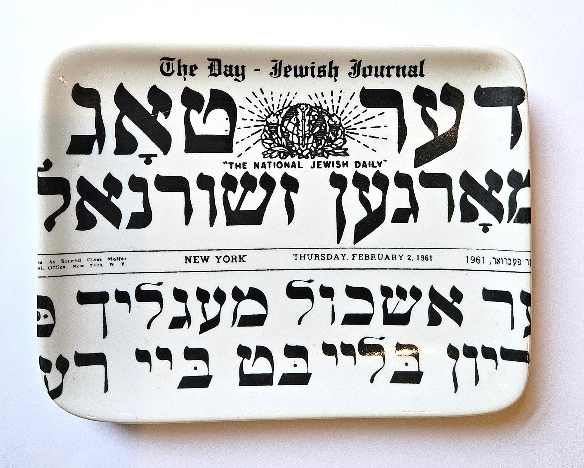 Piero Fornasetti Small Porcelain Ashtray,
The Day- Jewish Journal, 1961,
Written in Yiddish

The oval small dish is designed with a newspaper banner and part of a front page. It is titled at the top 