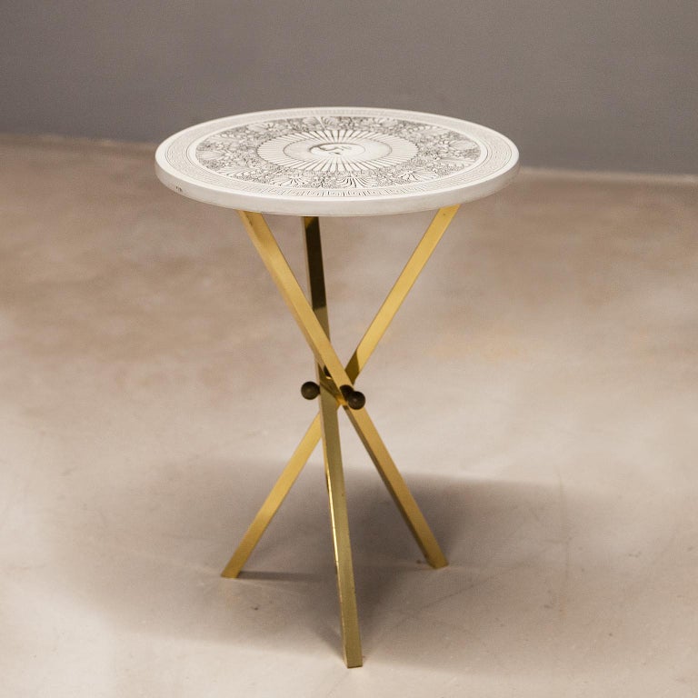 Piero Fornasetti Sole Brass tripod side table
This gorgeous collectors item is a ’Sole' side table by Piero Fornasetti, signed underneath with its original label. The side table is made with lacquered wood that has a white and various grey tones