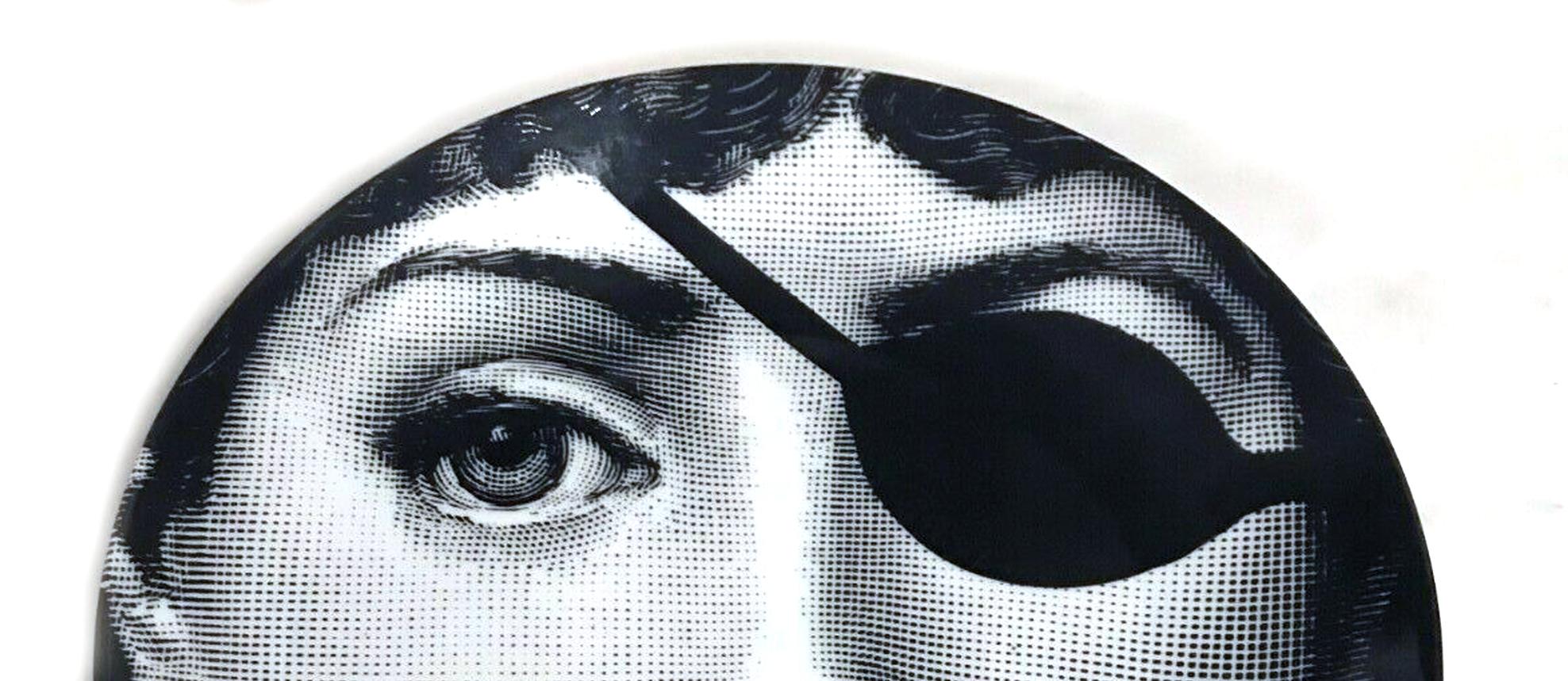 Piero Fornasetti Themes & Variations porcelain plate, #8,
Lina Cavalieri with Eye Patch,
1970s-80s.

Piero Fornasetti Tema E Variazoini Plate as it is known in Italian depicts the iconic image of Lina Cavalieri with an eye patch- a variation of
