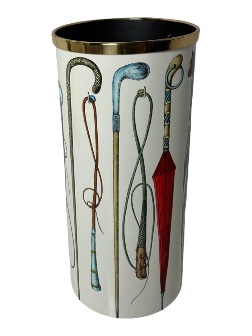 Enameled metal and brass umbrella stand by Italian designer Piero Fornasetti.
Decoration features umbrellas, canes, and riding crops in Fornasetti's signature graphic style.
Signed with label on the underside. 