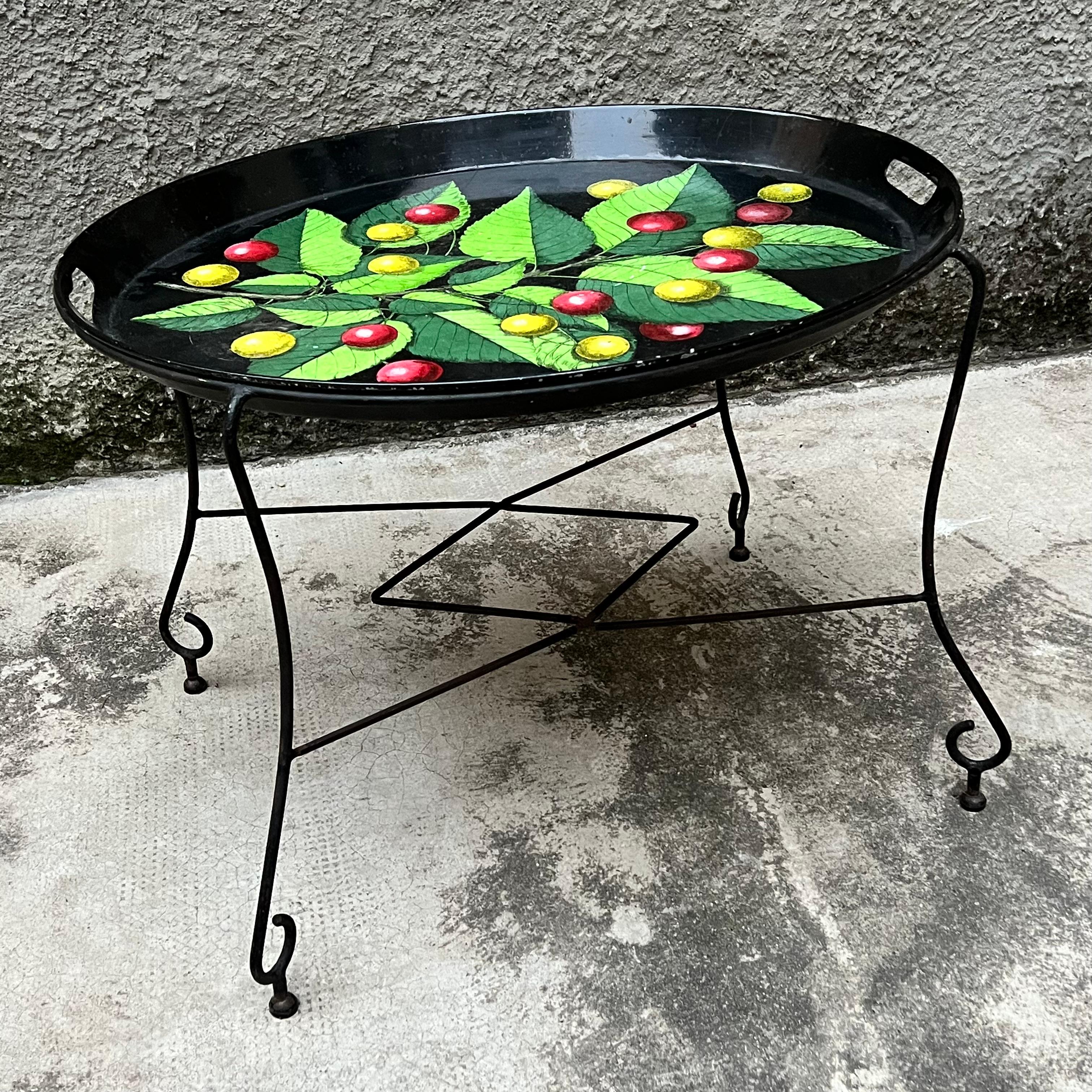 Large screen-printed metal tray, finely decorated with colorful and original motif of a cherry vine with leaves. The rather high edge fitted with two molded sockets ensures its functionality.
It also comes with a handcrafted stand made of painted
