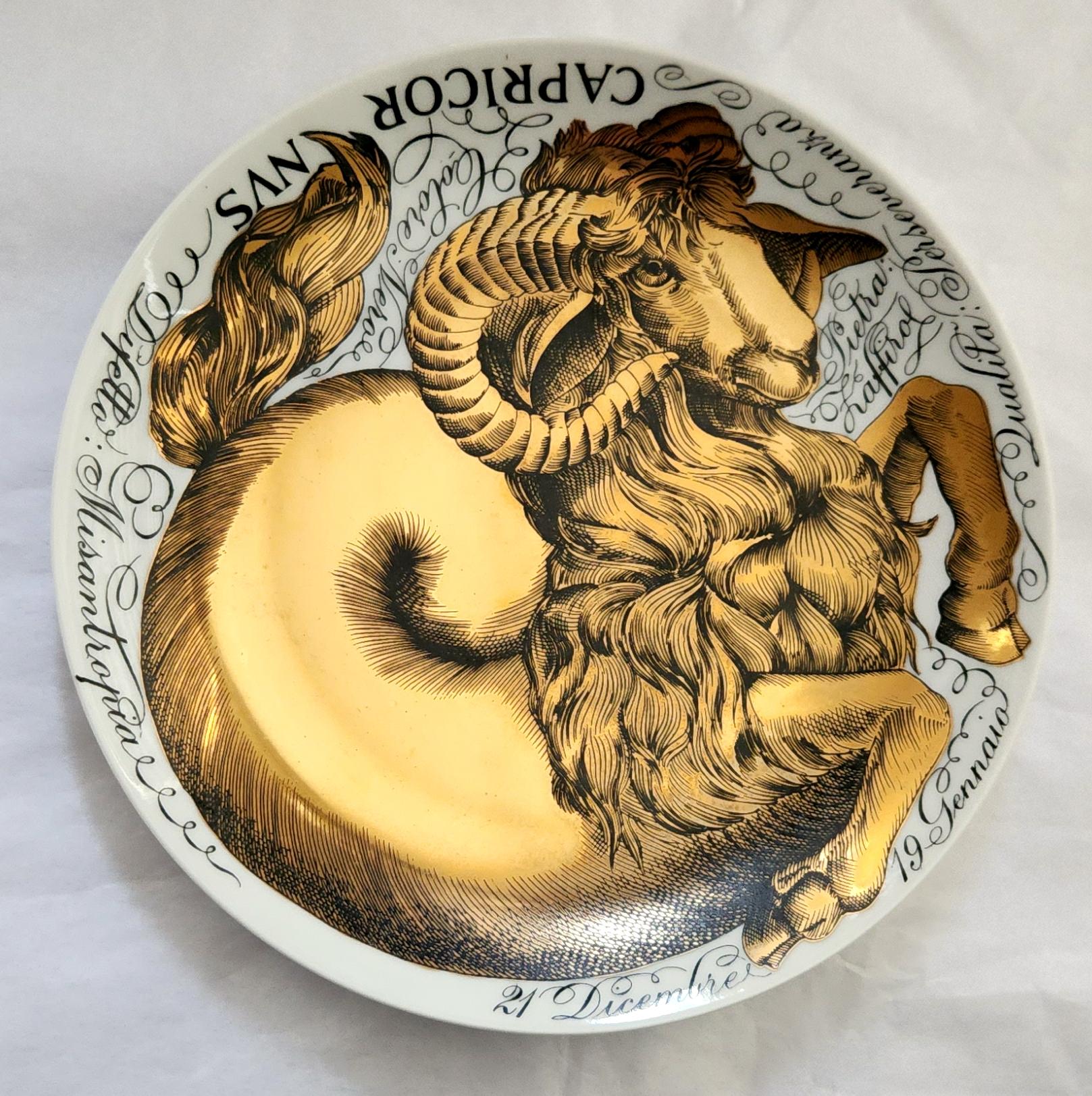 Piero Fornasetti Zodiac Porcelain Plate,
Astrological Sign of Capricorn,
Made for Corisia in 1964.

The plate in black and gold depicts the astrological sign Capricorn with words, intertwined around the form of a ram, with characteristics of the
