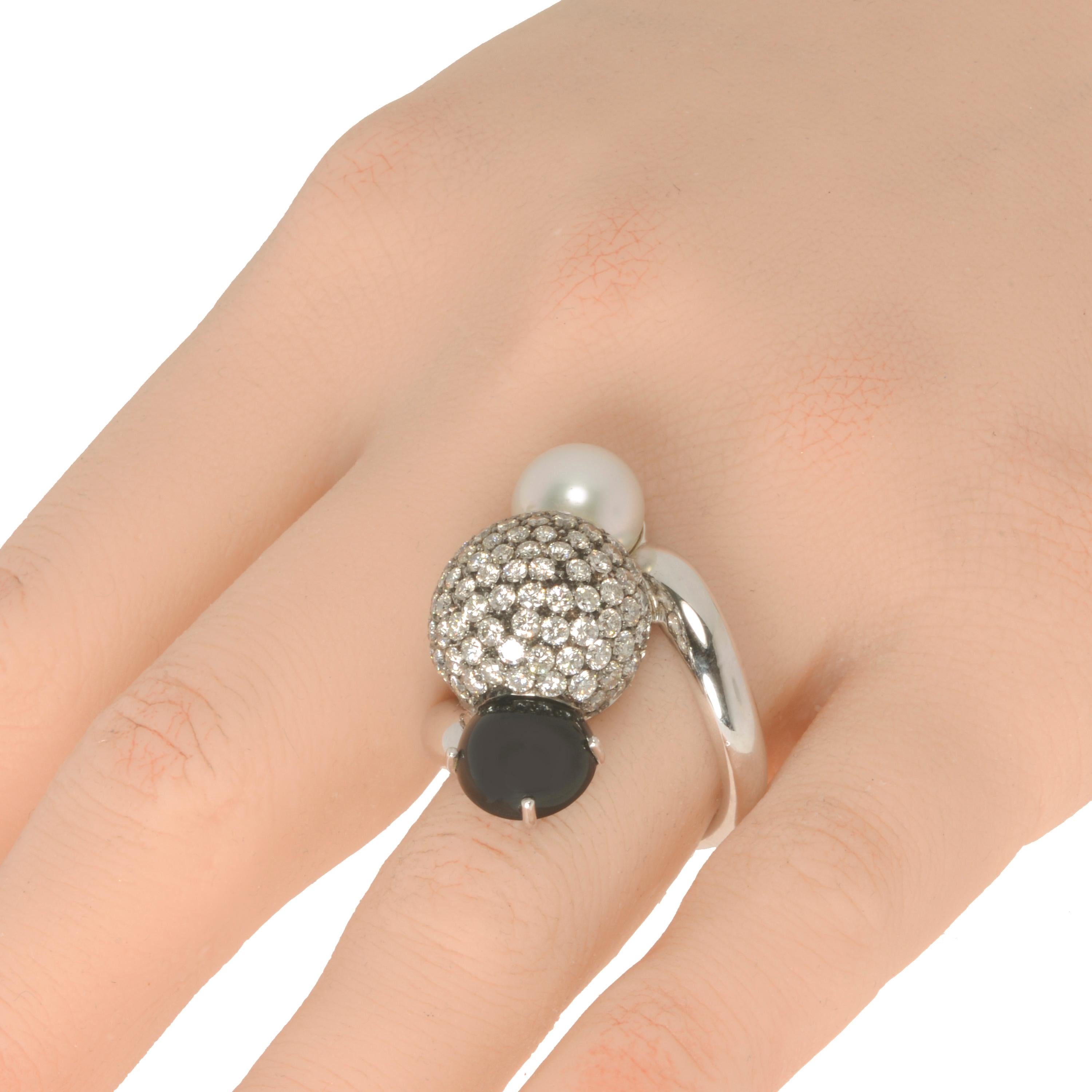 This bejeweled Piero Milano 18K White Gold Cocktail Ring features a shimmering sphere of diamond pave 3.39ct twd with a semi-precious black Onyx 0.3ct on one side and a luminous white 1.2g pearl on the other. The ring size is 7.5. The Decoration