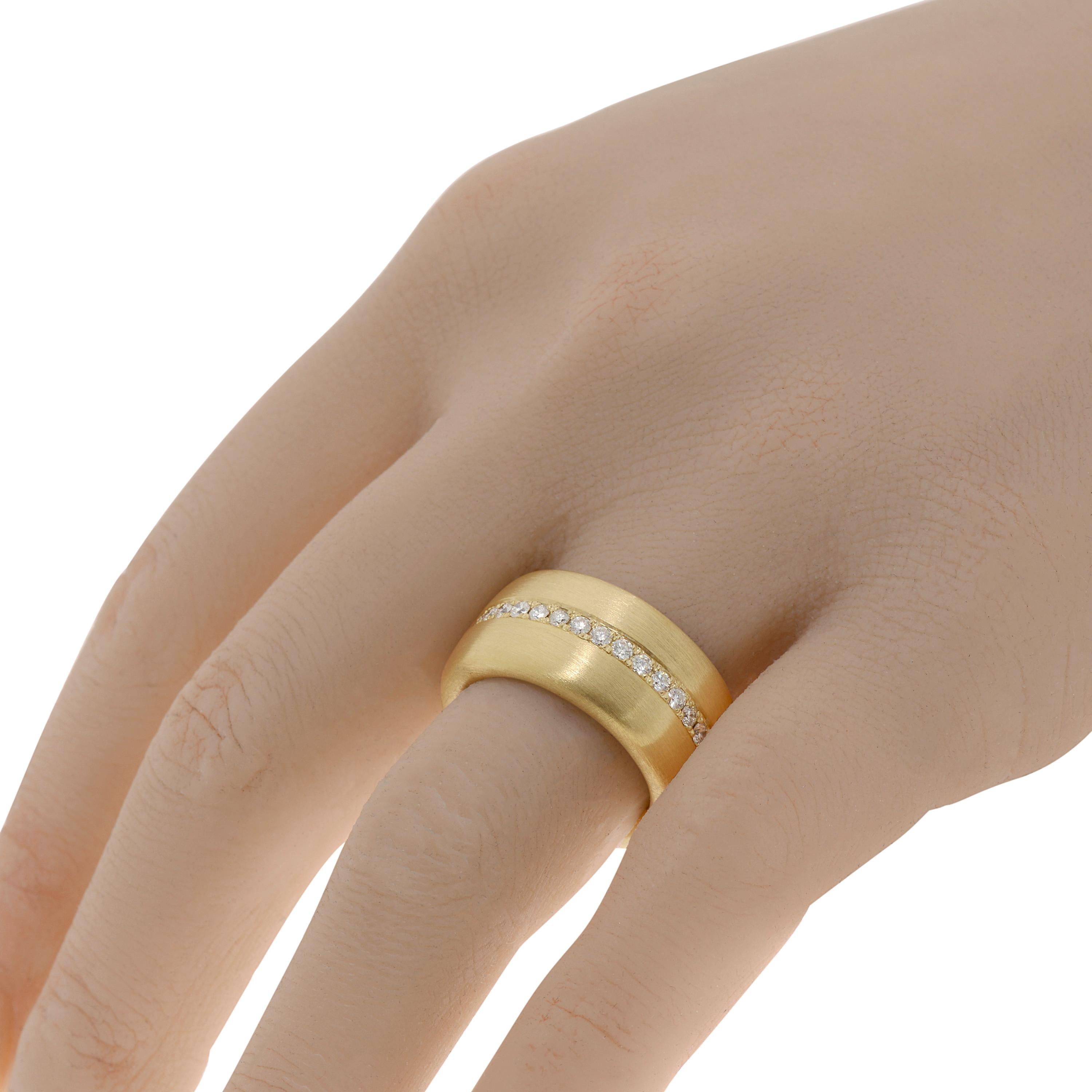 This classic Piero Milano 18K Yellow Gold Band Ring features a glistening line of diamonds 0.8ct. tw. adorning the center of a brushed 11.1mm Yellow Gold band. The ring size is 7.25 (55.1). The Band Width is 11.2mm. The Weight is 13.6g.
