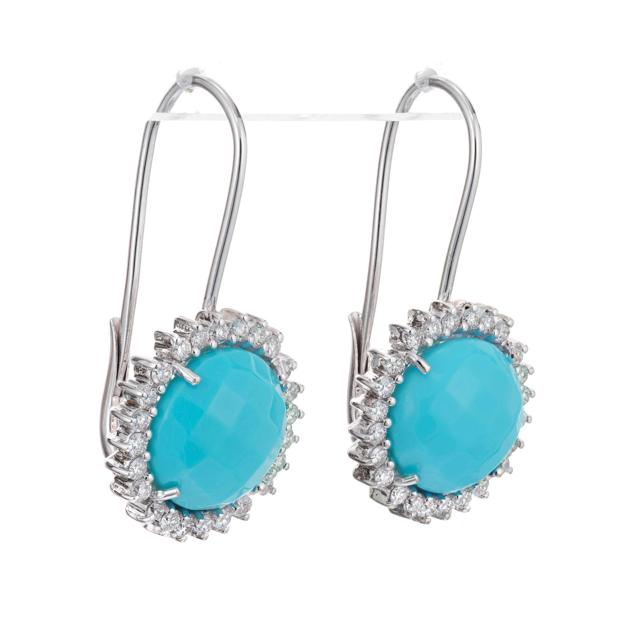 Turquoise and diamond halo dangle earrings. Cabochon turquoise in 18k white gold settings with diamond halos. Long top wires with clip backs.

48 round full cut diamonds, approx. total weight .92cts, G, SI1
2 round Turquoise, 12mm- 12.15mm
18k white