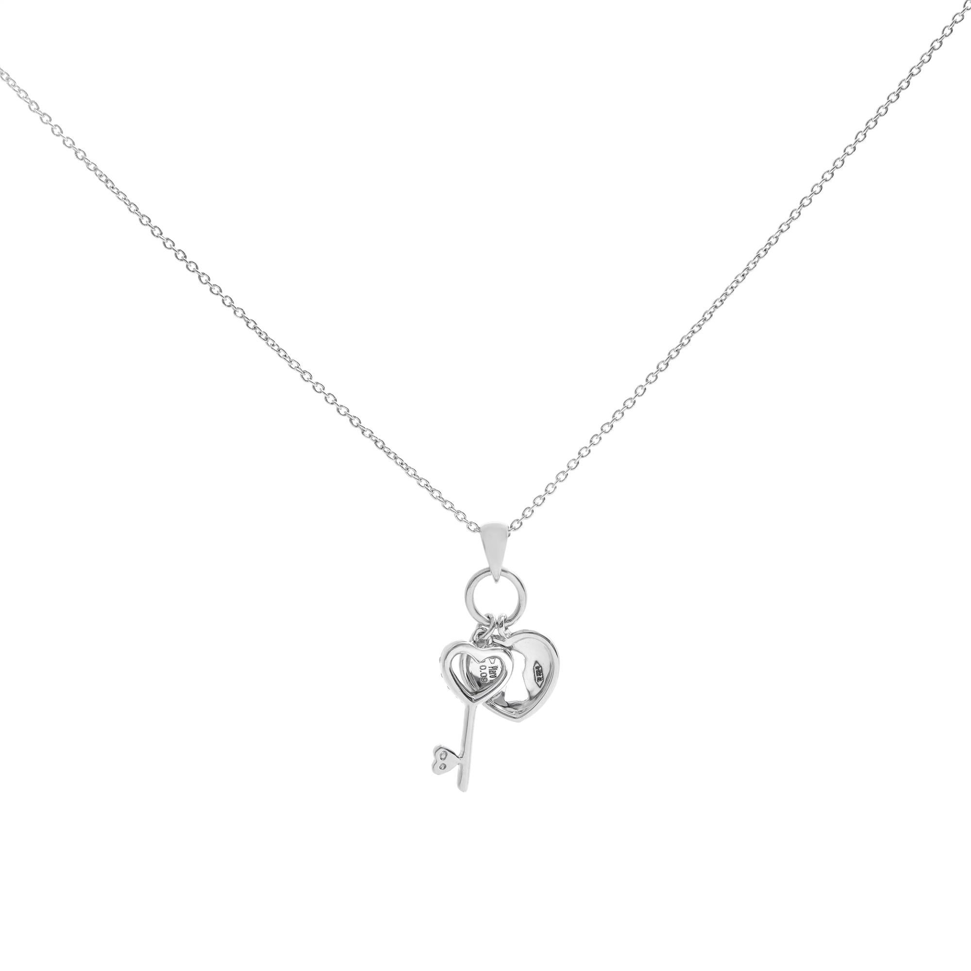 This is an 18k White Gold Piero Milano Heart Lock & Key Necklace. Sparkling Round Diamonds Adorn the Dangling Key along with a White Gold Heart Necklace. Crafted of 18K White Gold, the Pendant has a total Diamond Weight of 0.09 cttw, 16 inches long,