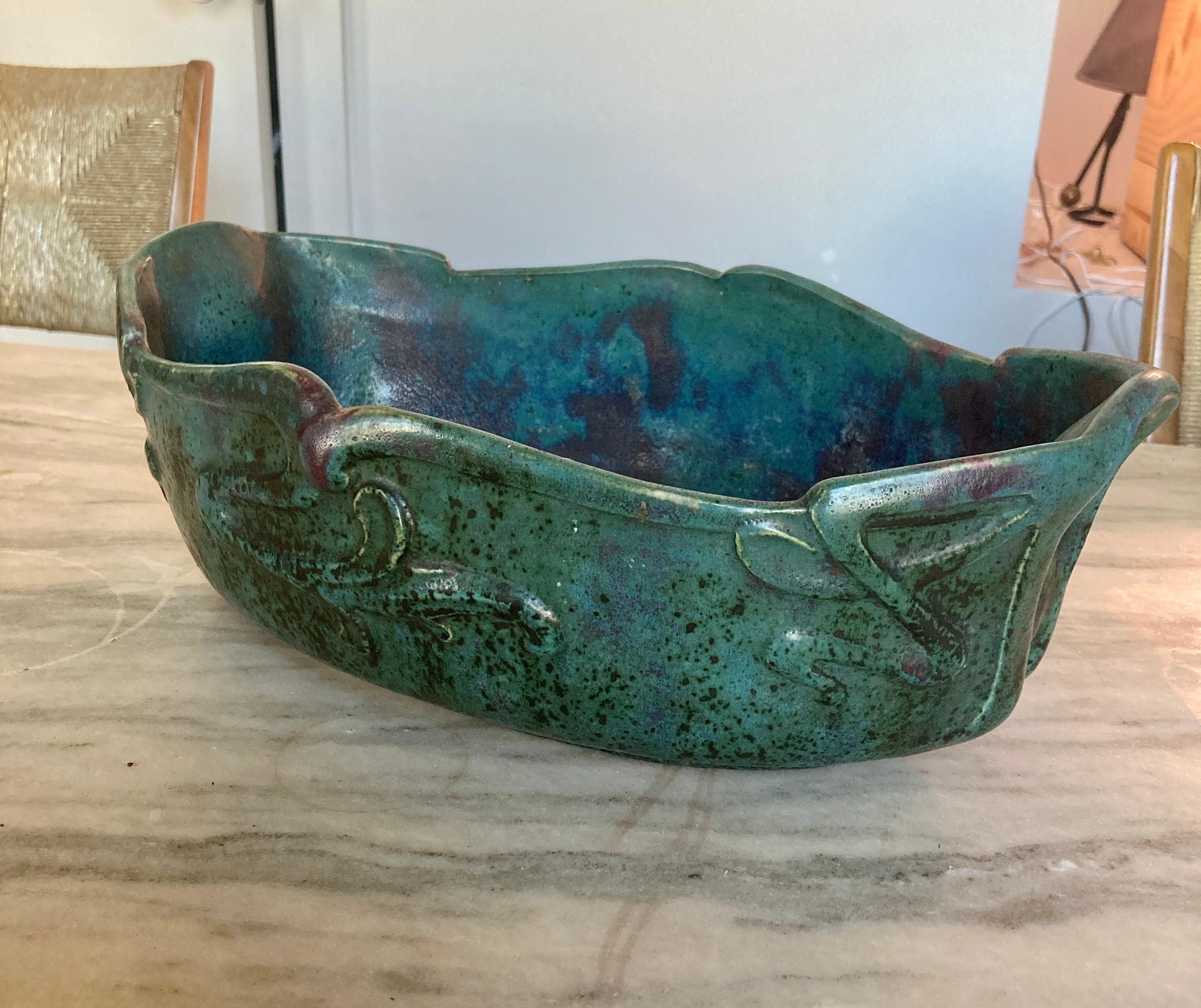 Flambe glazed stoneware, the boat-shaped vessel hand carved with stylized floral designs and glazed in an overall green with burst of reds and purples, circa 1900, France. Signed to underside.