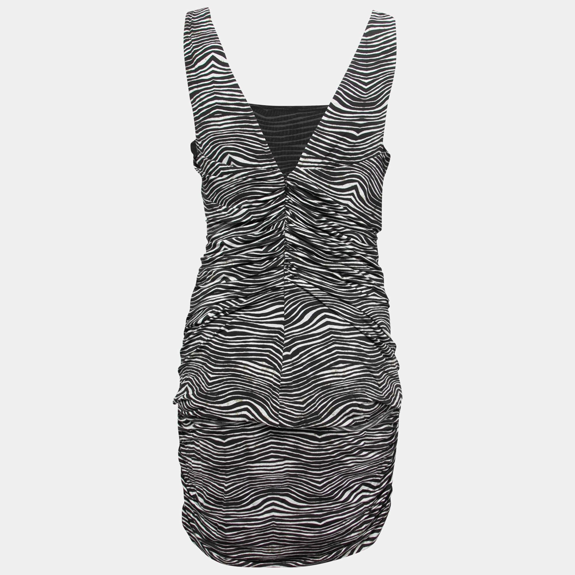 L'abito di Pierre Balmain è caratterizzato da un design drappeggiato e da una stampa zebrata su tutta la superficie. Di lunghezza mini, ha un'ampia scollatura e uno stile senza maniche. Realizzato con tessuti di lusso, è leggero e comodo da