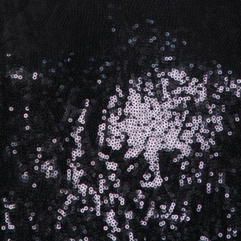 Questo top di Pierre Balmain dimostra la sua maestria nel creare silhouette classiche. Realizzato in maglia di qualità, è ricoperto di paillettes. Questa creazione nera ha una silhouette oversize, maniche corte, collo ampio e vestibilità rilassata.