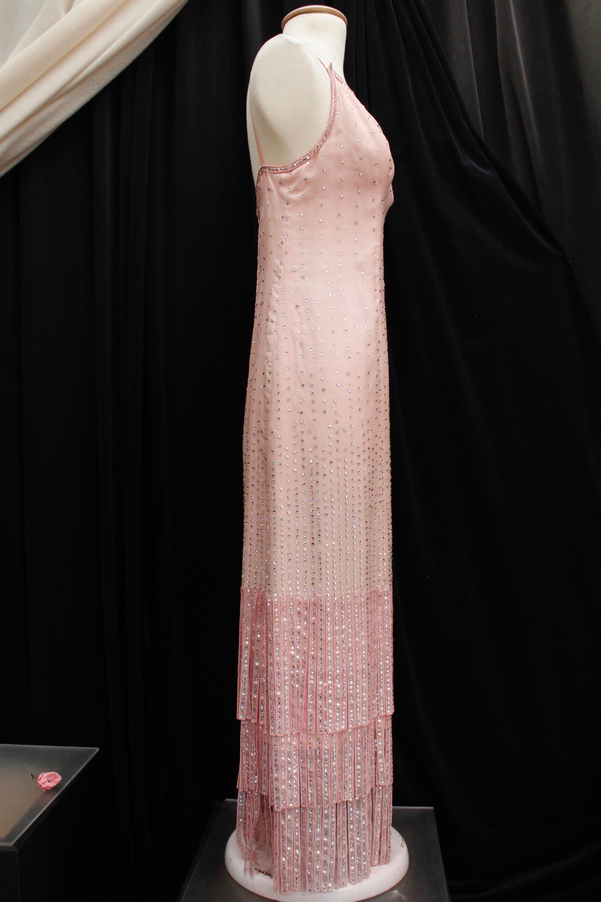 PIERRE BALMAIN Paris (Made in France) – Nice long evening dress composed of light pink organza embroidered with rhinestones. It features a straight cut, a V-neck and thin shoulder straps? The bottom of the dress is composed of three strands of