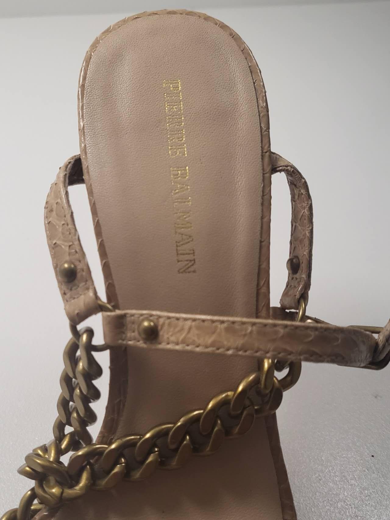 Ti presentiamo l'epitome della raffinatezza e dello stile: i sandali muli con tacco alto in pelle di serpente beige e nudo di Pierre Balmain, taglia 36. Eleva il tuo ensemble con questi lussuosi sandali mulo, realizzati in pelle di serpente di prima