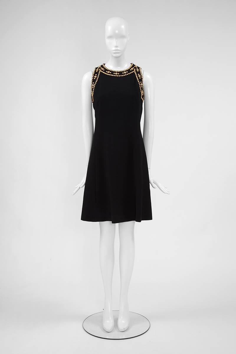 So easy to wear ! This great late 60’s - early 70’s Balmain Boutique dress is cut from refined black crepe and embellished with round gold metal studs around the shoulders and neckline. This sleeveless dress is ultra flattering and very chic for any