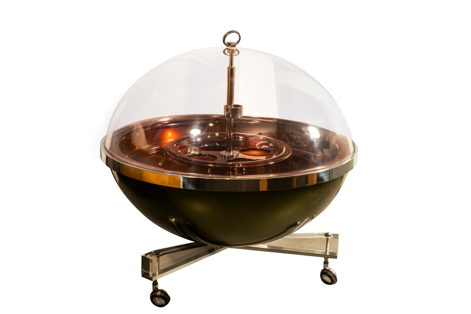Pierre Cardin (1922-2020), 
Spherical low cocktail, 
Chromed metal, Perspex, rubber castors feet,
Lift-up top,
France, circa 1970.

Measures: Height 65 cm, diameter 110 cm.