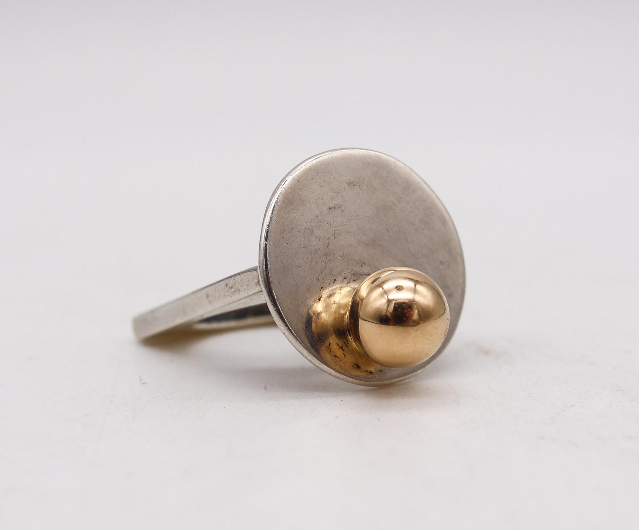 Geometrischer Ring, entworfen von Pierre Cardin.

Wunderschönes modernistisches Stück, das der Pariser Modedesigner Pierre Cardin in den 1970er Jahren in Frankreich entworfen hat. Dieser geometrische, skulpturale Ring wurde mit minimalistischen