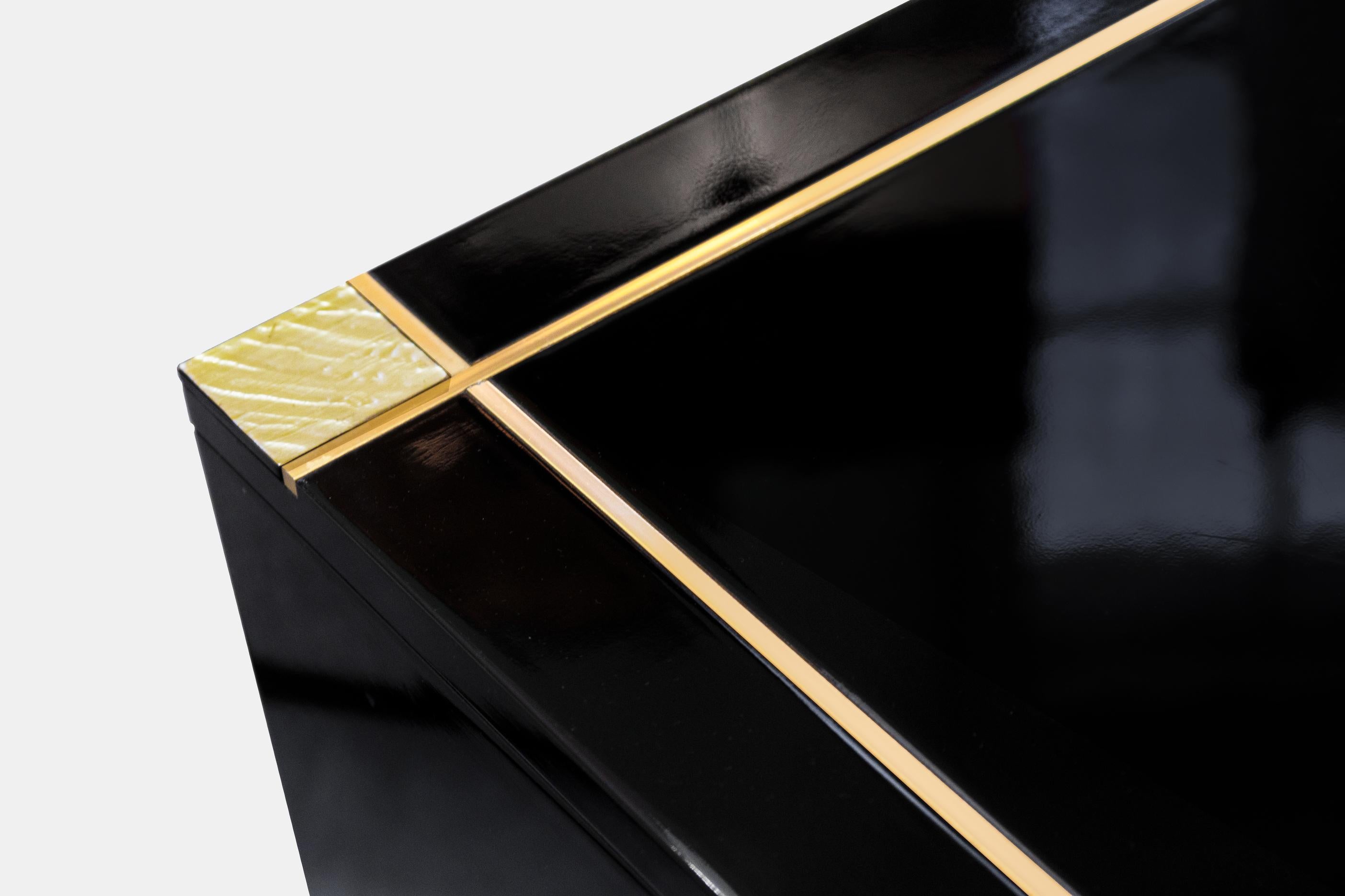 Pierre Cardin (Italie, 1922 - France, 2020)
Exceptionnelle table basse carrée, circa 1970. Cette pièce étonnante présente du bois laqué noir avec d'élégantes incrustations de laiton, illustrant l'esthétique audacieuse et futuriste de Cardin dans les