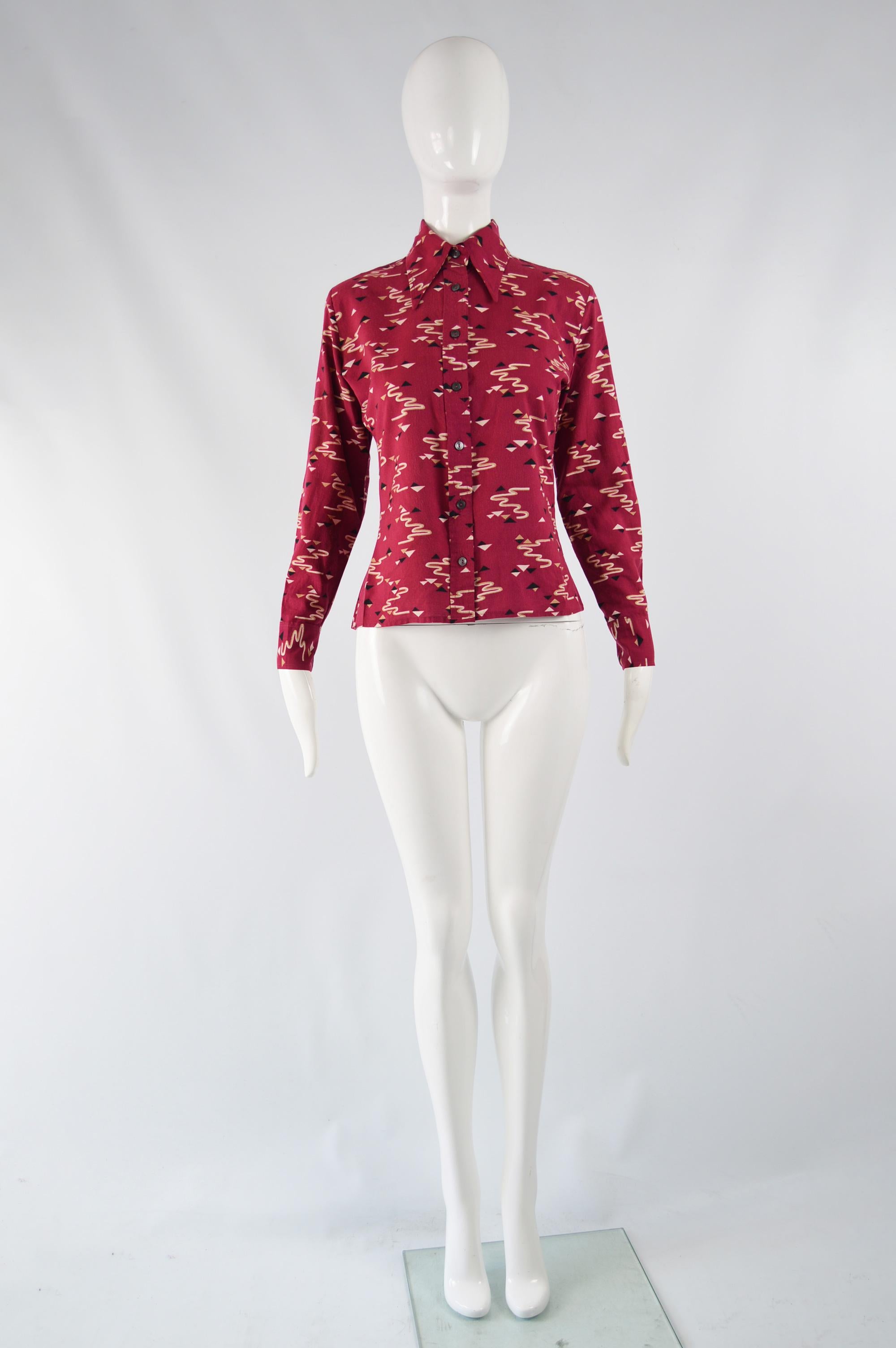 A fabulous vintage women's blouse / shirt by legendary French fashion designer, Pierre Cardin. In a red acrylic knit with Cardin's famous love of geometric shapes shown through the futuristic pattern and long, pointed collar. It has a slim fit and
