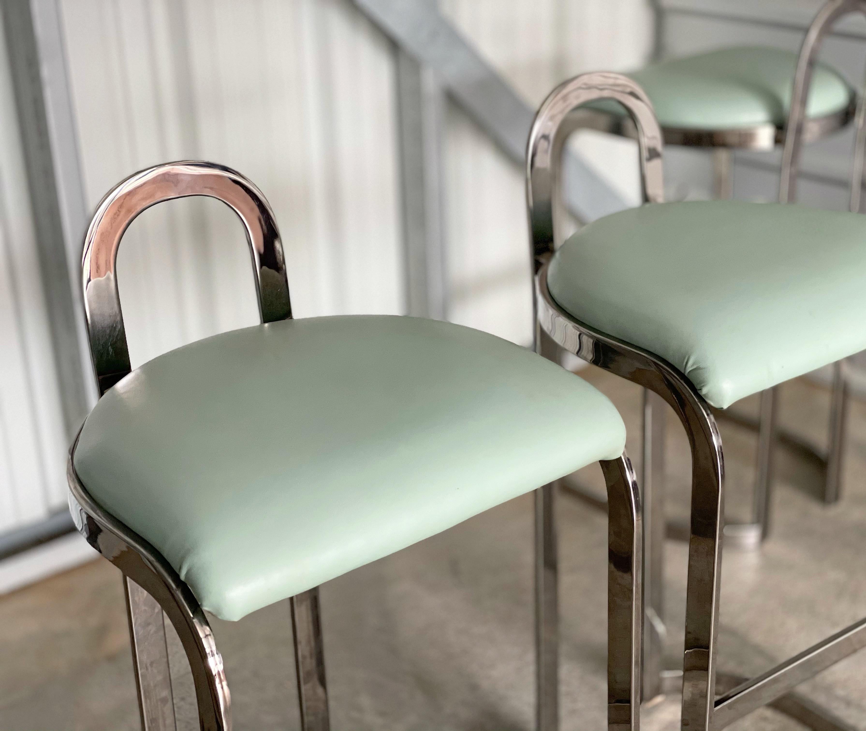 Scarce set of four Pierre Cardin bar height barstools in chromed steel and seafoam green Naugahyde. This set is unique on the market. Modern design with a nod to Art Deco and Hollywood Regency. Excellent original and unaltered condition. Chrome