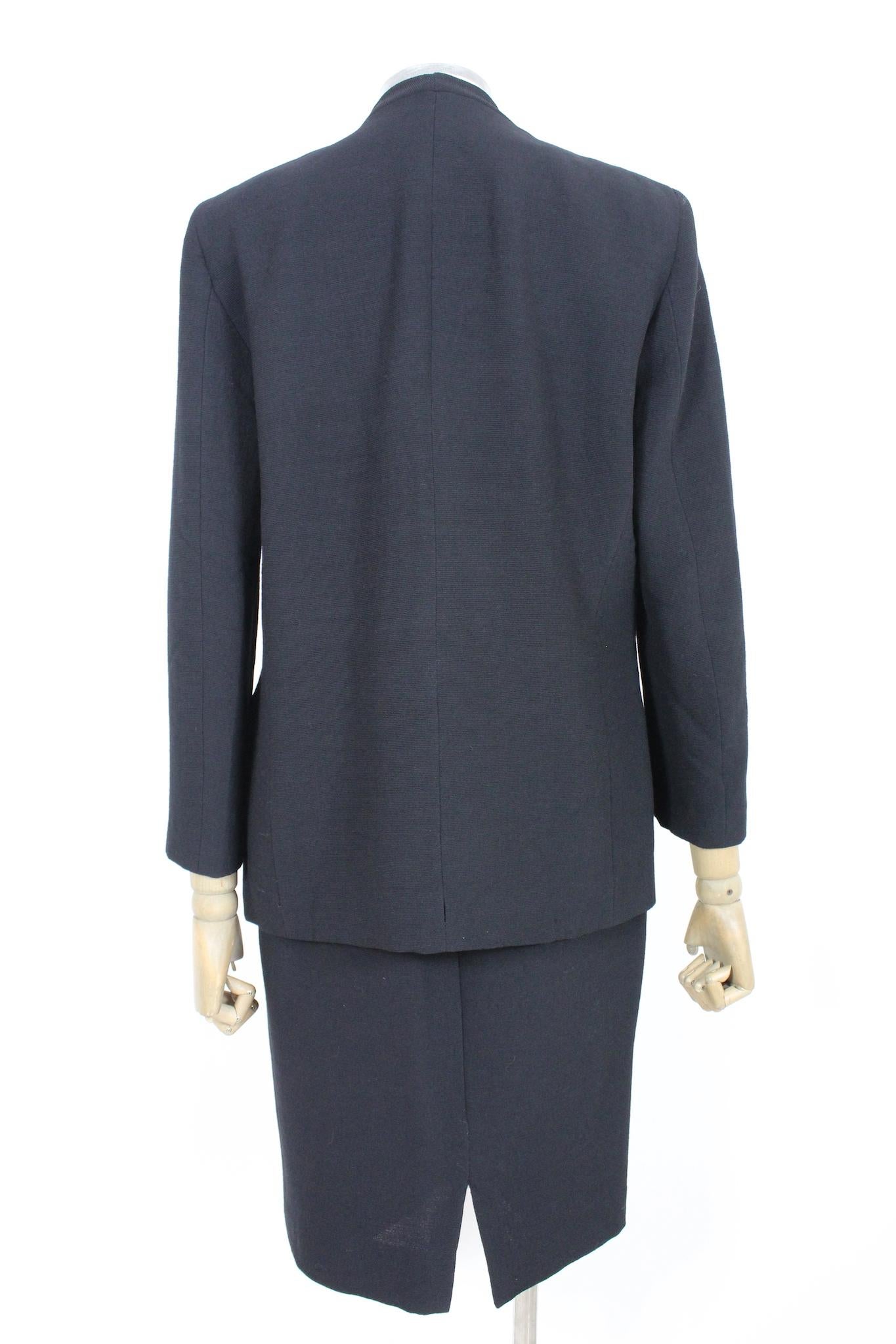 Cet élégant costume vintage Pierre Cardin est le complément parfait de toute garde-robe féminine. La veste et la jupe noires sont fabriquées dans un tissu en laine de haute qualité et présentent un détail de boutons brodés. Le design vintage des