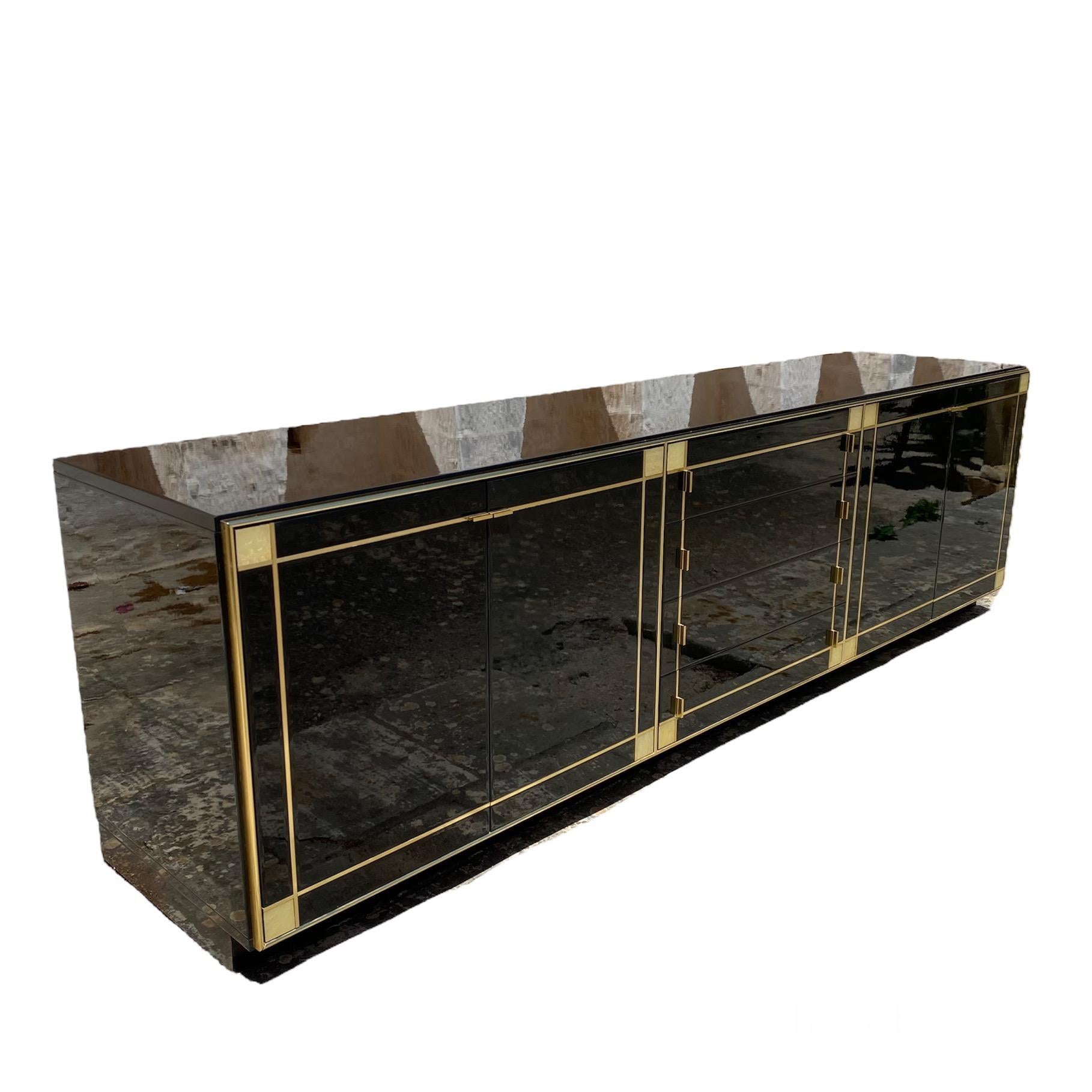 Wonderful Vintage sideboard by Pierre Cardin produced by Roche Bobois in black lacquered wood, mother of pearl and brass characterized by thick brass lines that frame the sideboard itself.
The glossy black lacquer, combined with bright brass