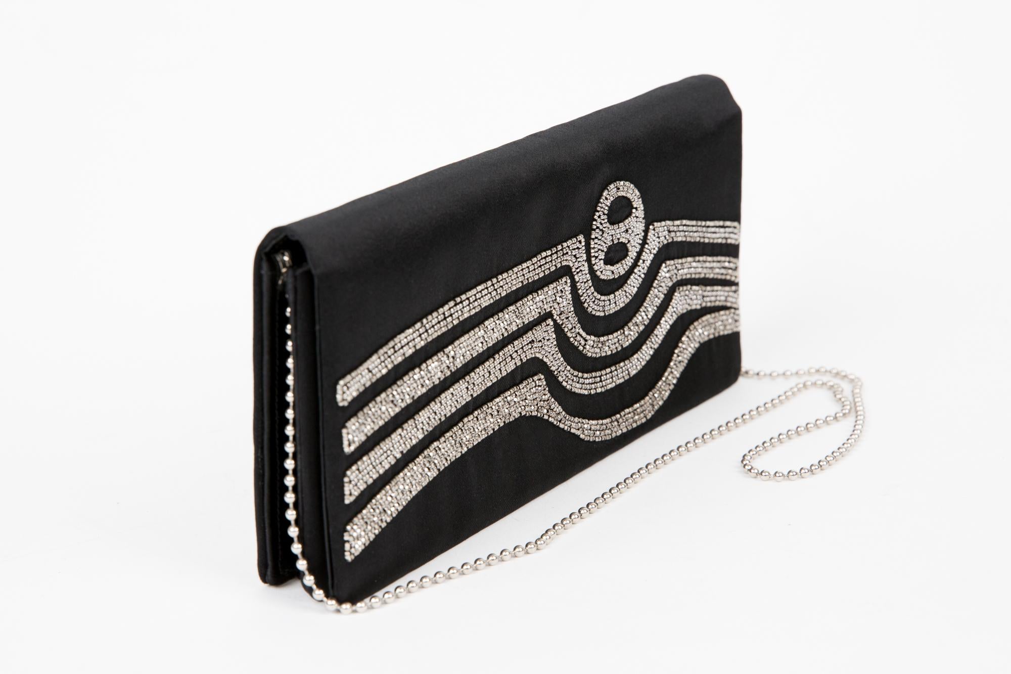 Pierre Cardin black silk evening clutch bag featuring front embroidered, silver-tone hardware and shoulder chain strap, a snap under the front flap,  an inside  stamp. Delivered in original box.
In good vintage condition. Made in France. 
Length: