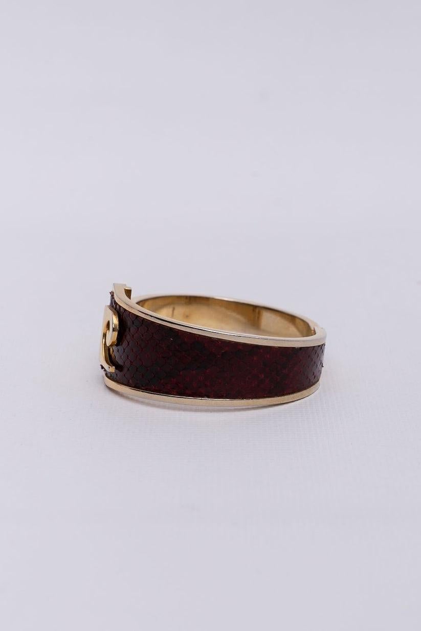 Pierre Cardin - Golden metal bracelet with burgundy lizard.

Additional information:
Condition: Very good condition
Dimensions: Circumference: 17.5 cm (6.88