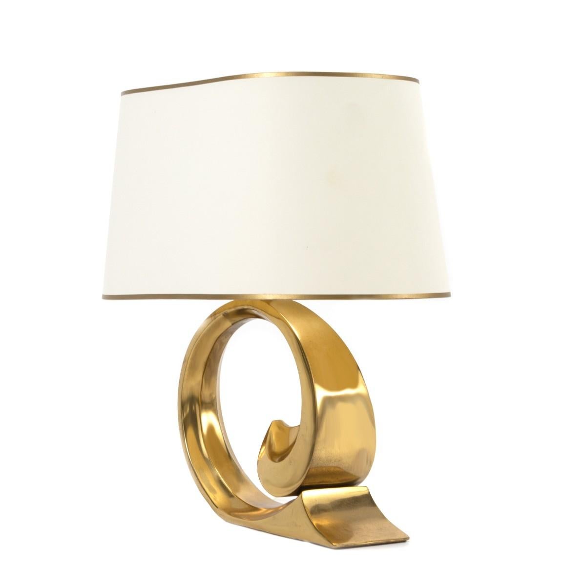 A vintage polished brass table lamp by Pirre Cardin, USA, circa 1970. Includes a custom oval-shaped shade with gold trim.

Dimensions of lamp base: 12 inches L × 4.5 inches W x 19.5 inches H
Dimensions of shade: 18 inches L x 11 inches H.