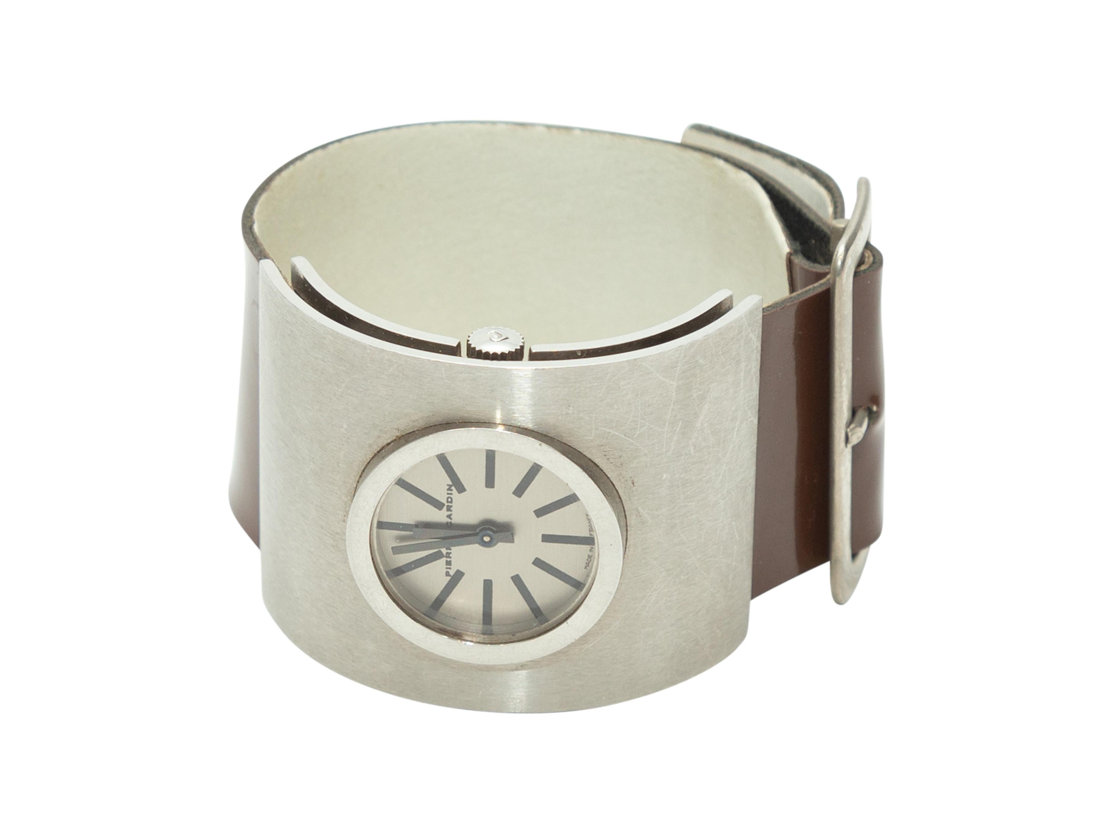 Product Details: Vintage brown patent leather and white leather wide watch by Pierre Cardin. Silver buckle closure at back.