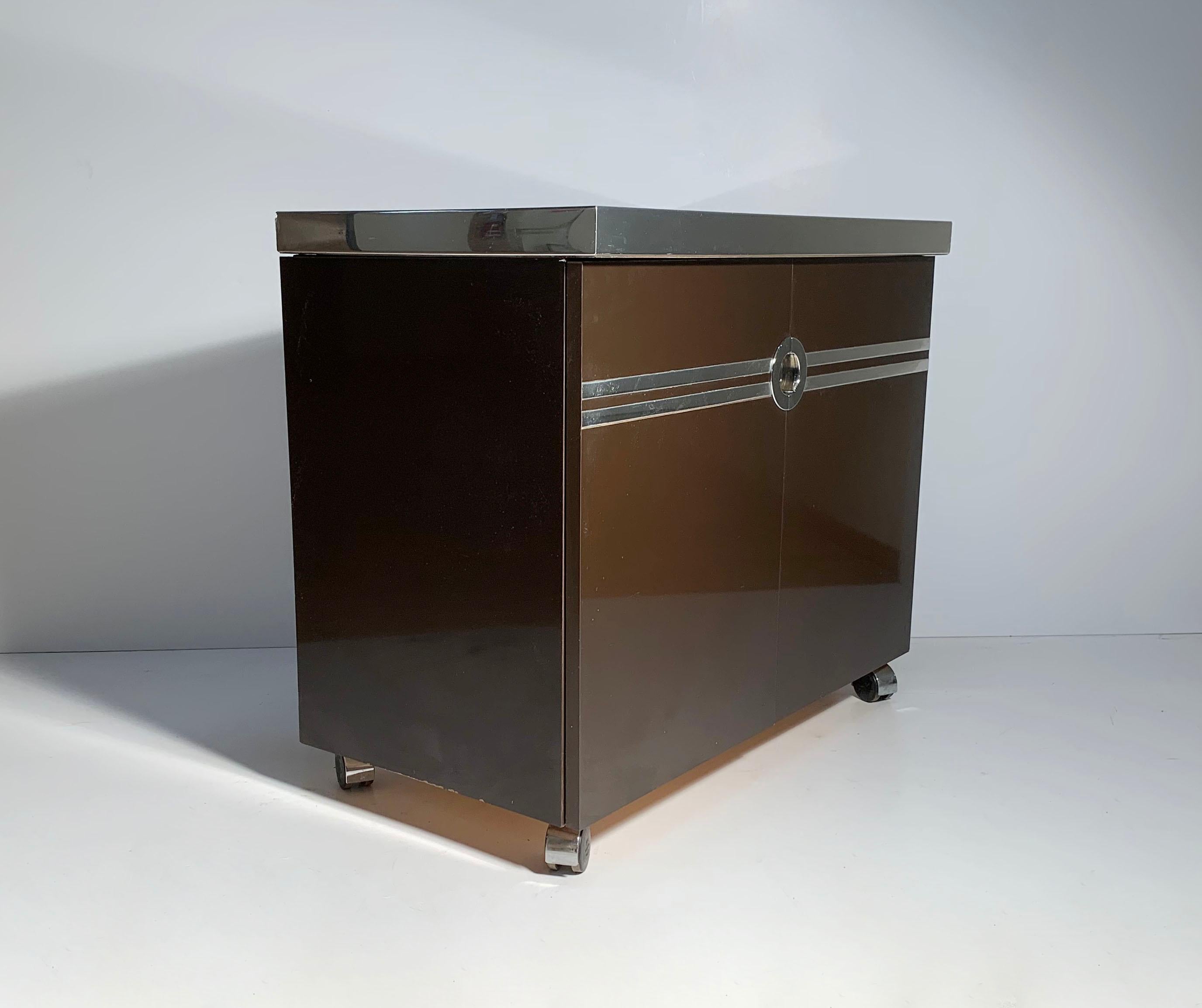 Pierre Cardin bar cabinet on castors.

Some vintage wear. The chrome band on one end has some scuff scratches (shown in picture). Otherwise pretty clean overall in nice vintage condition. Castors roll smoothly. Style of Willy Rizzo, Milo Baughman