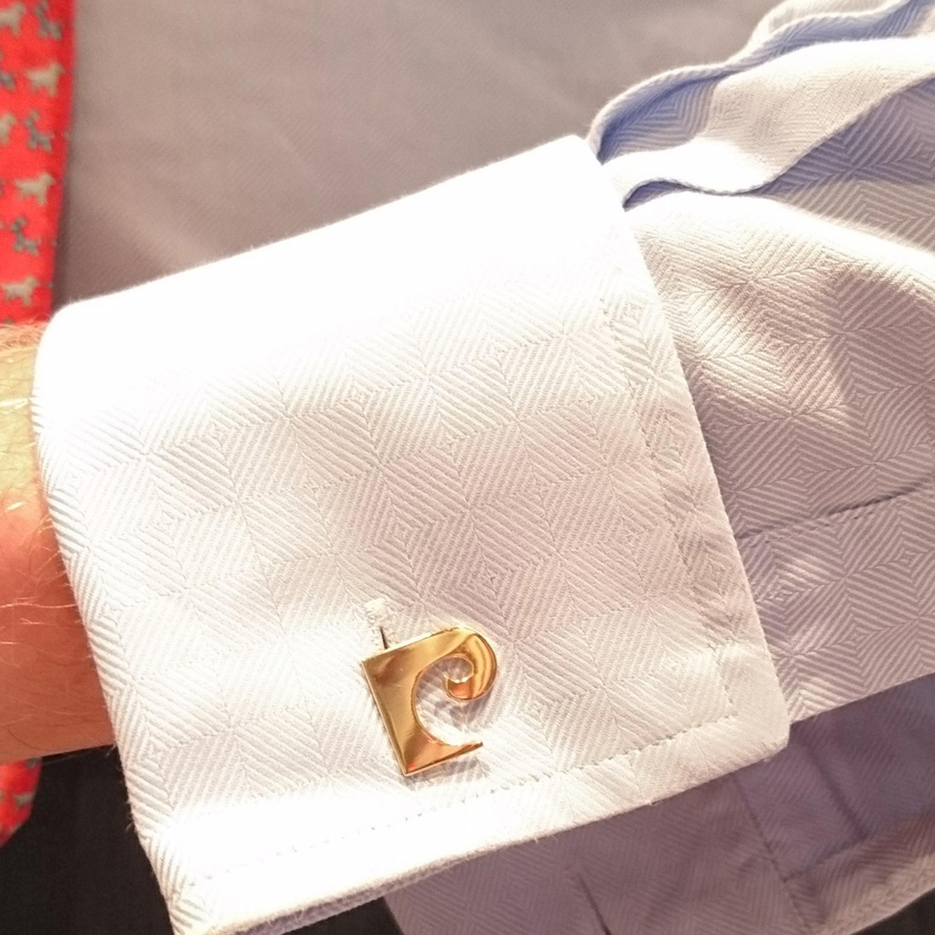 Un paio di gemelli da polso Pierre Cardin, con l'iconico logo di Pierre Cardin, con finiture girevoli sul retro. Questi gemelli vintage, placcati in oro, sono contenuti nella custodia originale di Pierre Cardin. Circa 1960.