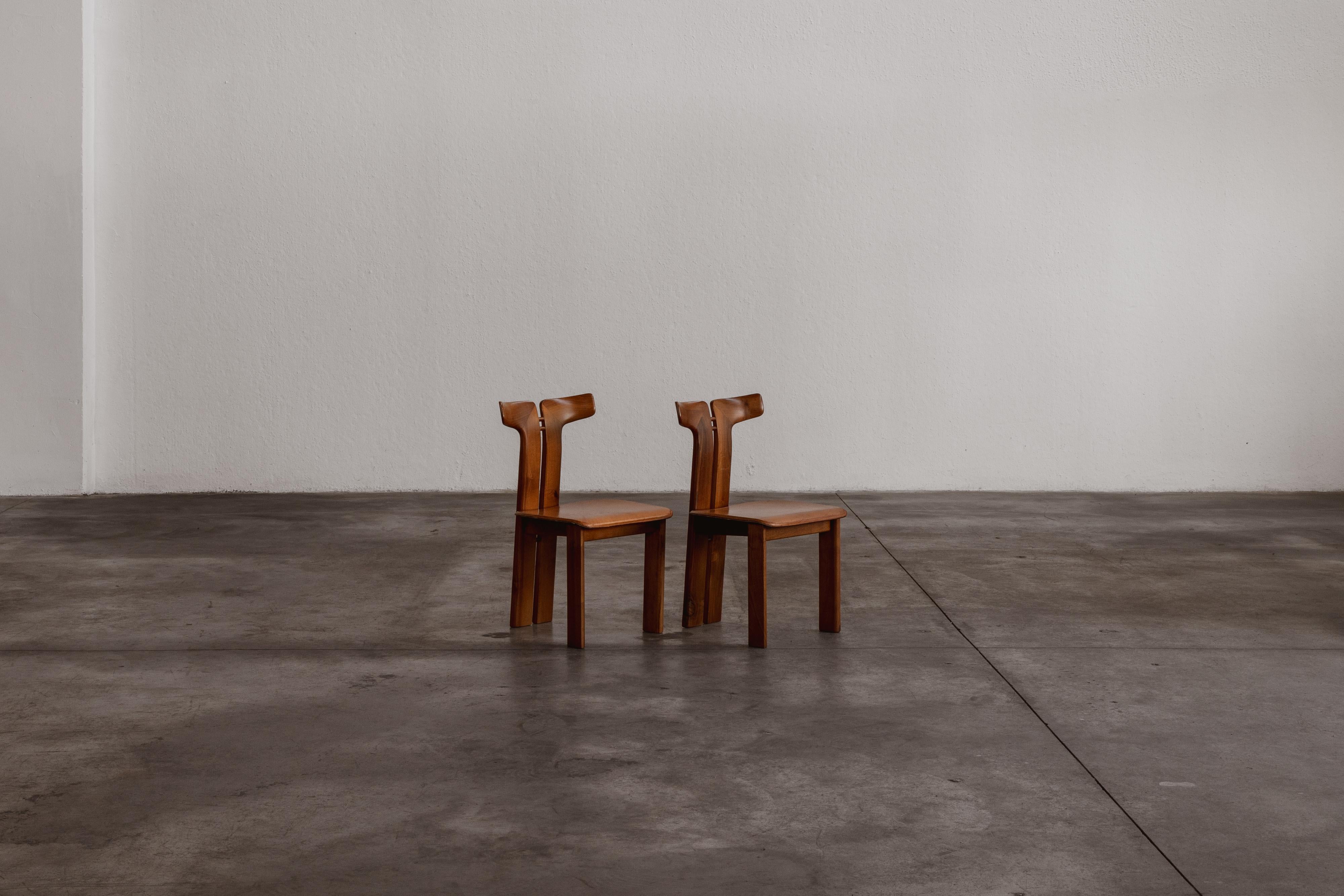 Pierre Cardin Esszimmerstühle für Roche Bobois, Holz und patiniertes cognacfarbenes Leder, Frankreich, 1970, Satz mit zwei Stühlen.

Pierre Cardin entwarf diese ikonischen Esszimmerstühle 1970 für Roche Bobois. Die Essenz des Designs liegt in der