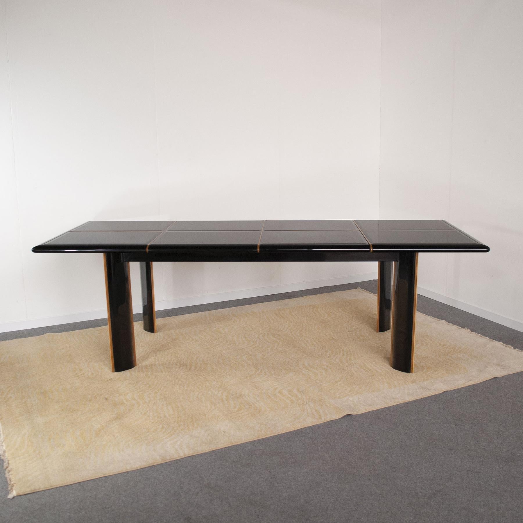 Large black lacquered extensible dining table with top composed of rectangular shaped lacquered glass elements, elegant inserts in light maple wood are present throughout the table, a model made in France by the designer Roche Bobois for Pierre
