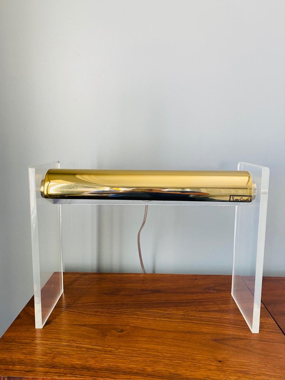 Beautiful lucite and brass table lamp by Pierre Cardin. A unique piece from the 1970s, this piece adds light and design to your space. Following the futuristic vision of Pierre Cardin, this table lamp demands attention due to its beauty and form. A