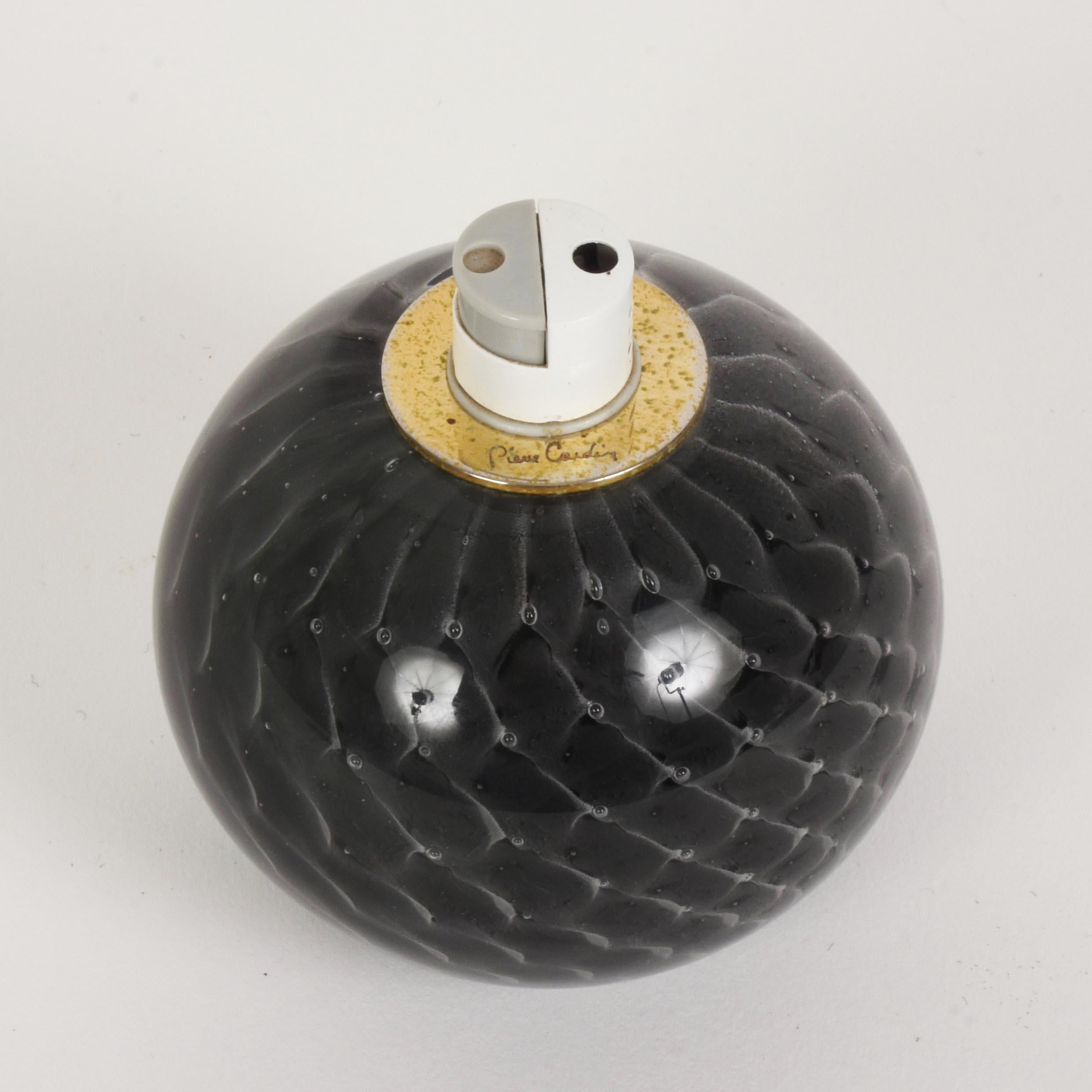 Incredible table lighter in the shape of a glass ball with air bubbles and brass signed Pierre Cardin and made in France in the 1970s.

The item has an infinite fascination for not having been used. It has wonderful round lines.

A precious