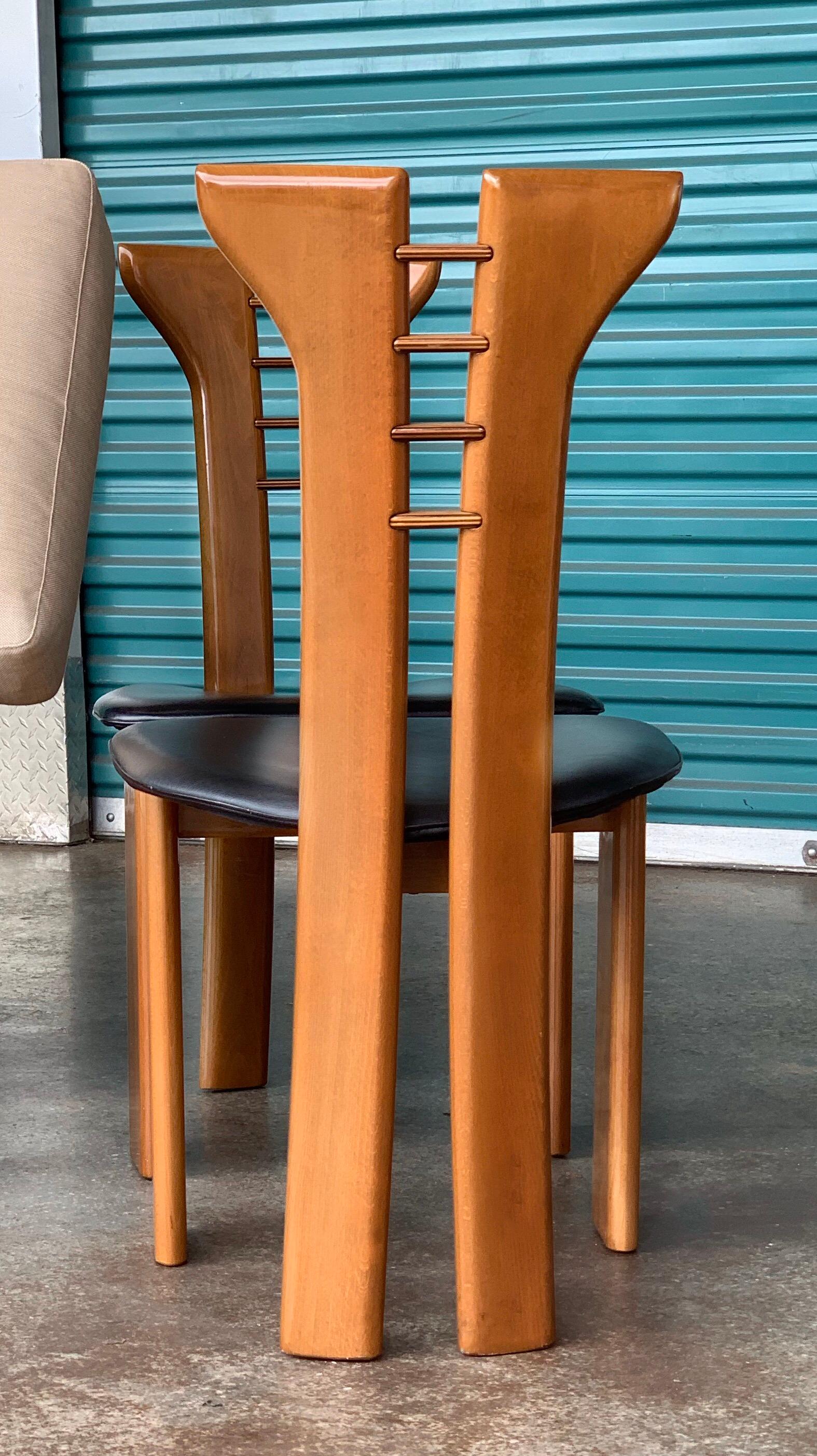 Set of six dining chairs by Pierre Cardin in very good original condition. Clear lacquer / Natural wood finish with black leather seats. Very rare color way. Most examples of this design by Cardin were sold with black lacquered wood and tan or black